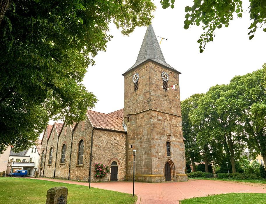 Alte Kirche in Hagen mit Turm und Bäumen im Vordergrund. Die Ehemalige Kirche Hagen ist ein Kulturzentrum mit wechselnden Ausstellungen und regelmäßig stattfindenden Konzerten.