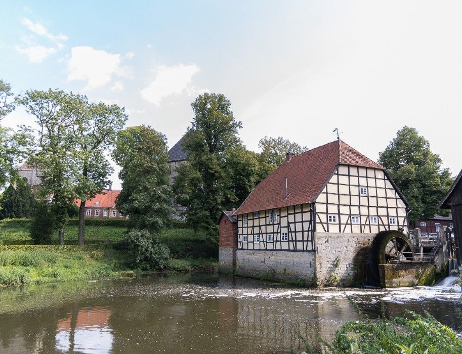Fachwerkhaus mit Wasserrad an einem Fluss in Rheda-Wiedenbrück.