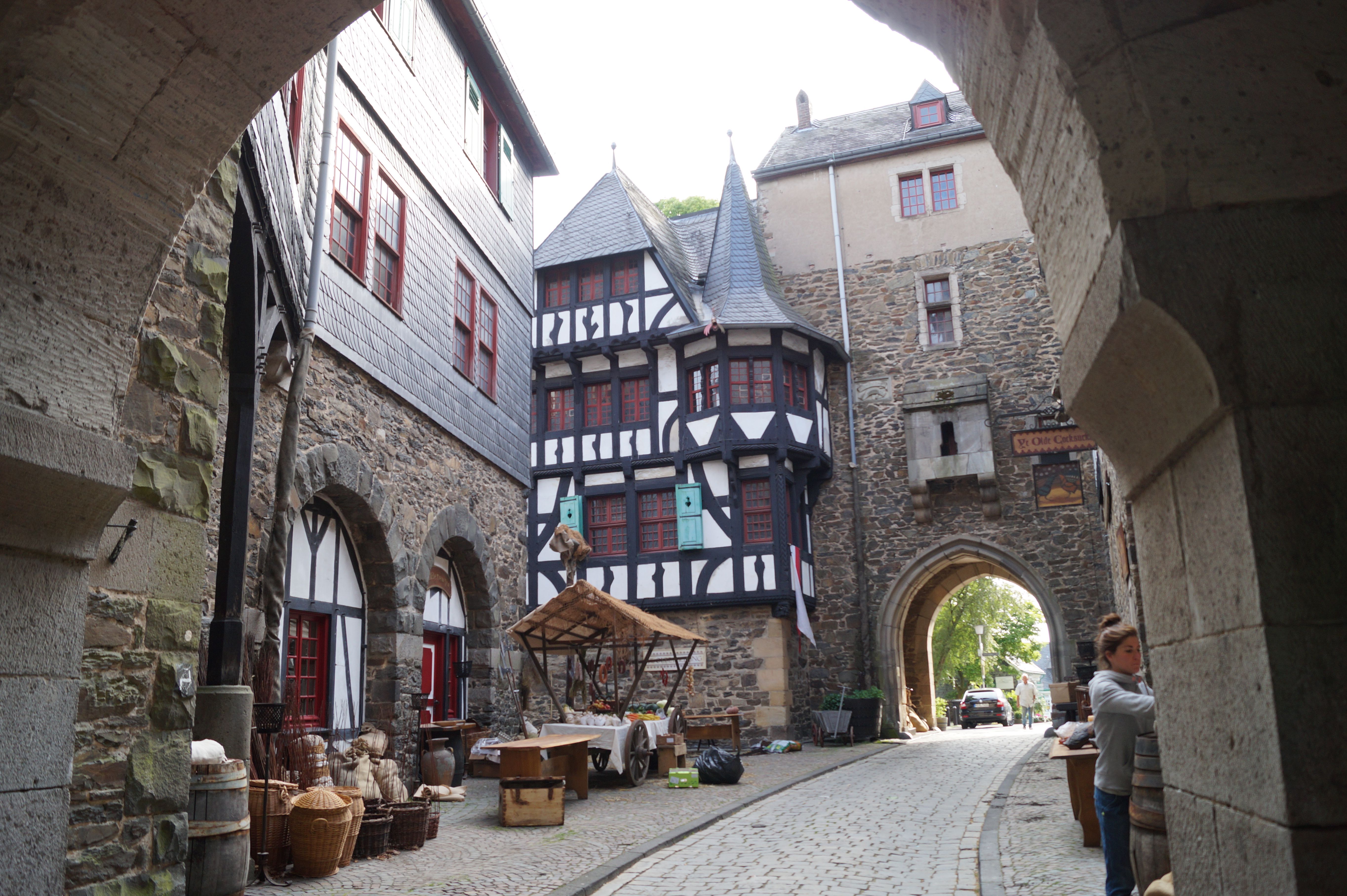 Innenhof von Schloss Burg mit Fachwerkgebäude und Torbogen.