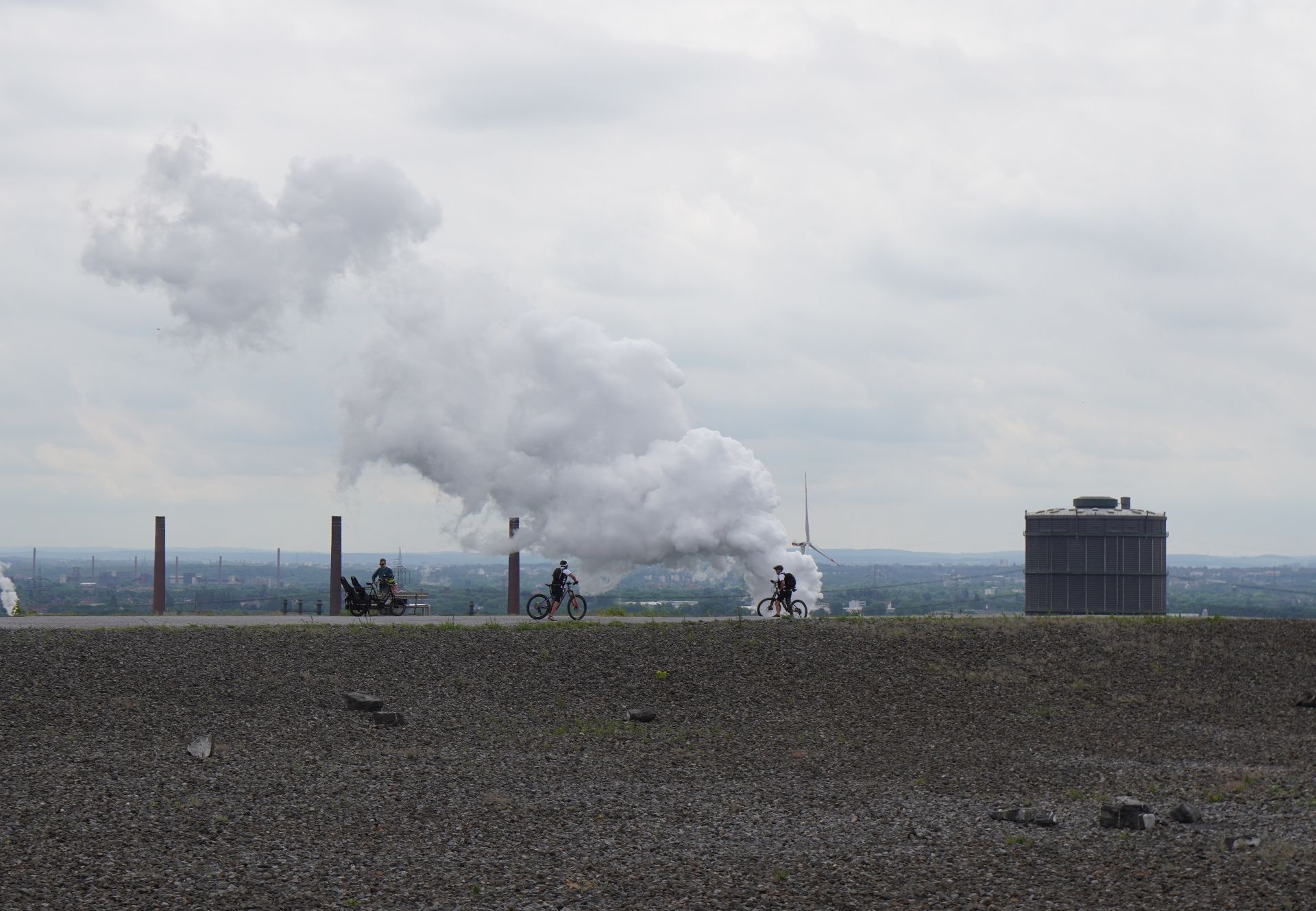 Fahrradfahrer fahren auf der Halde Beckstraße in Bottrop, im Hintergrund ist der Gasometer zu sehen
