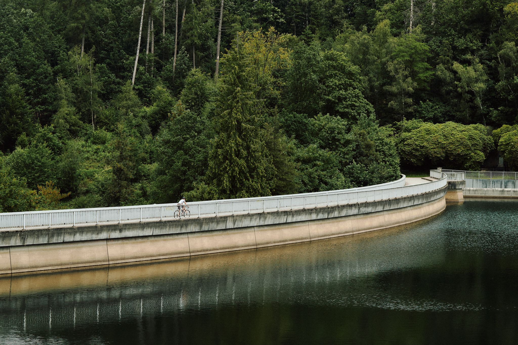 Person auf Gravelbike fährt auf Staumauer der Bevertalsperre 