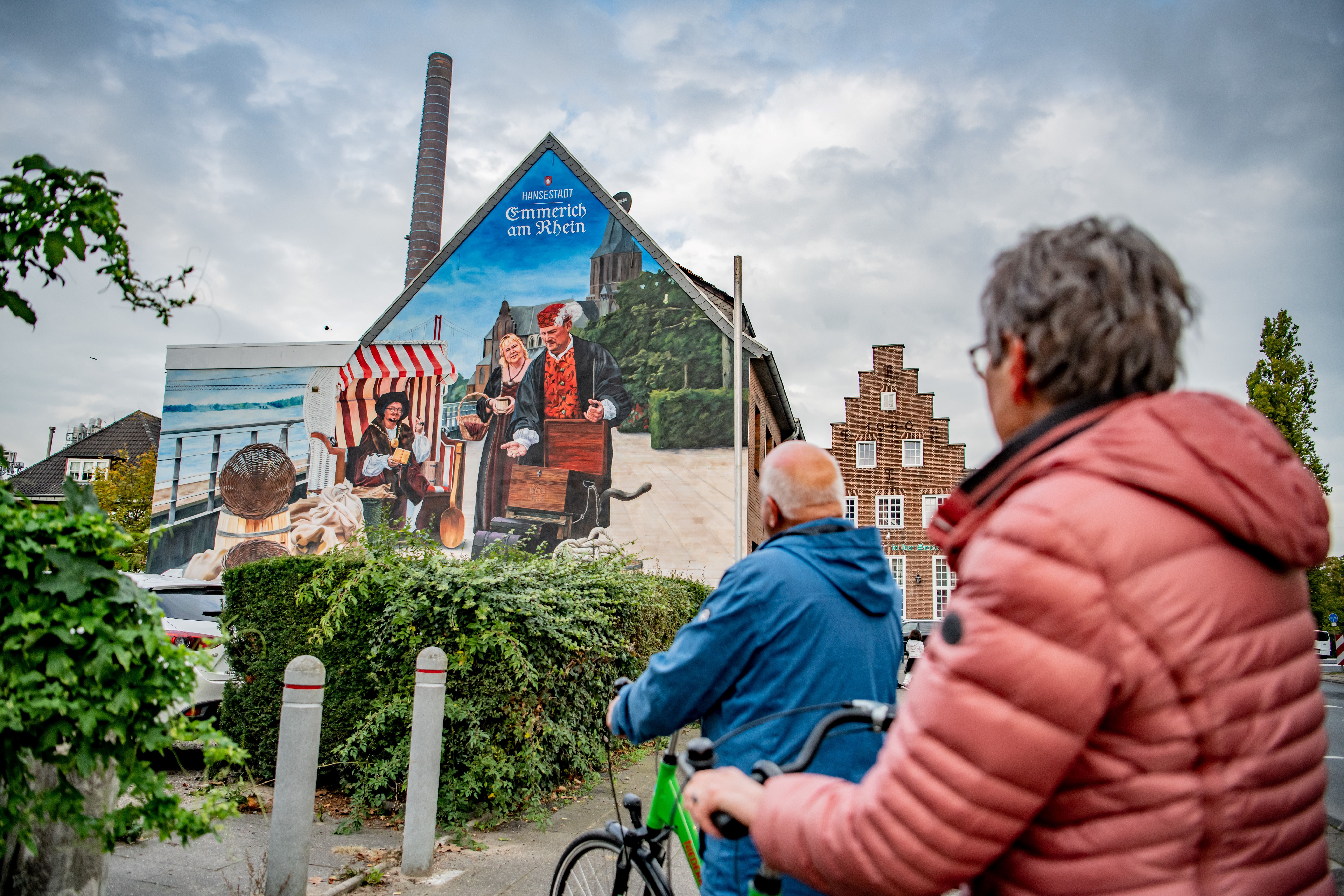 Das große Wandbild in Emmerich am Rhein zeigt historische Szenen im modernen Gewand