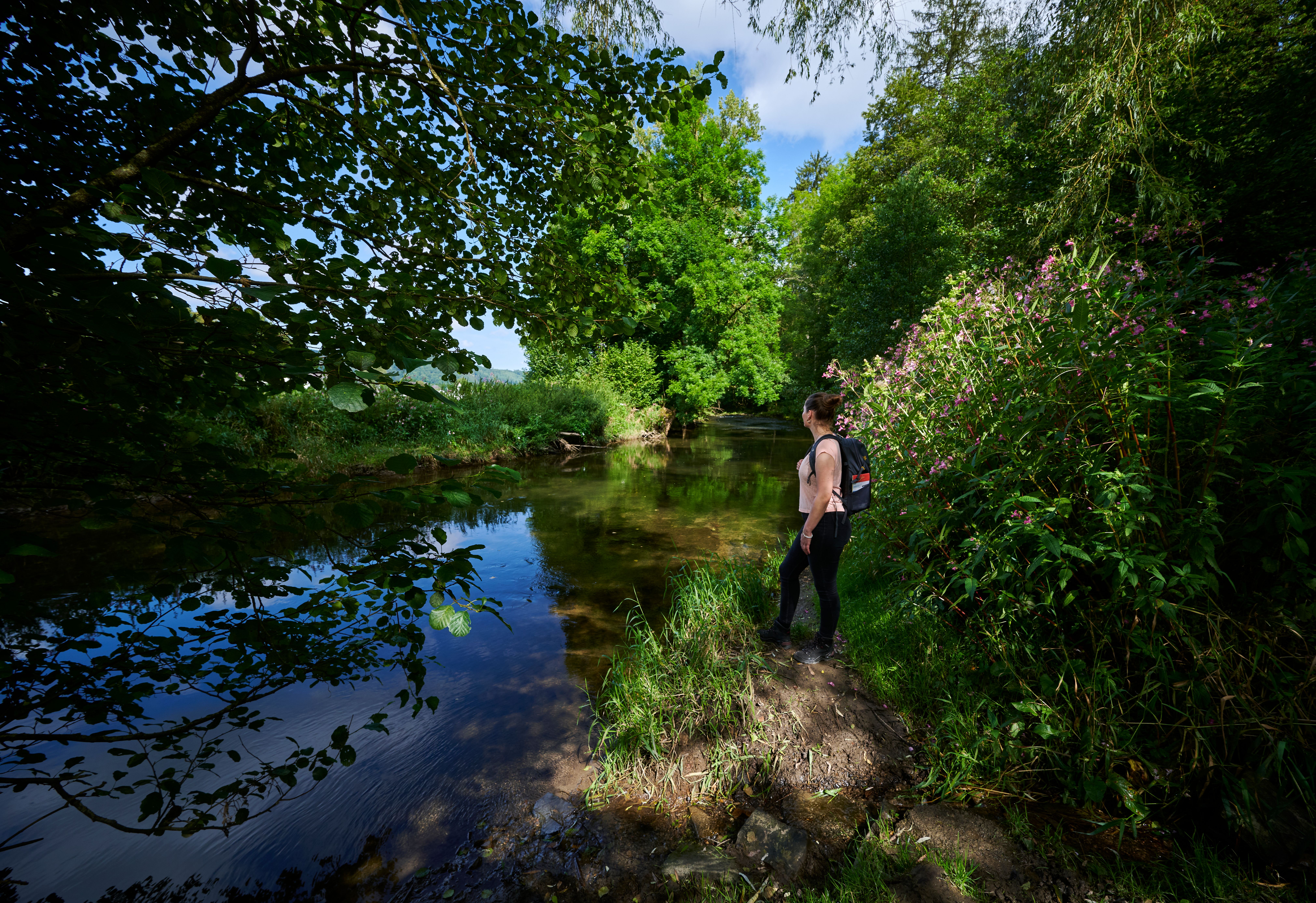 Frau am Ufer eines Baches.