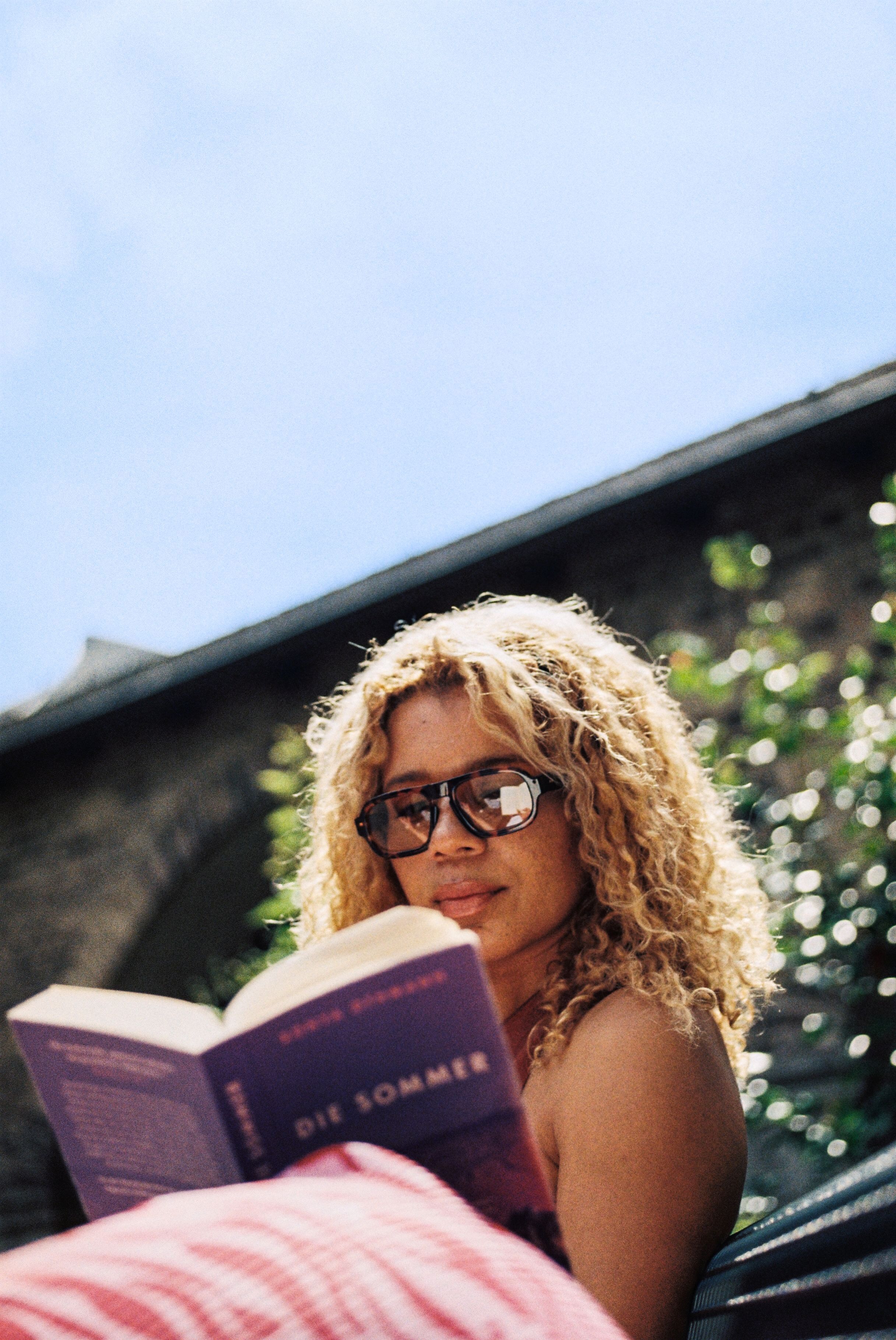 Frau auf Bank mit Buch im Garten der Sankt Maria Kapitol in Köln.