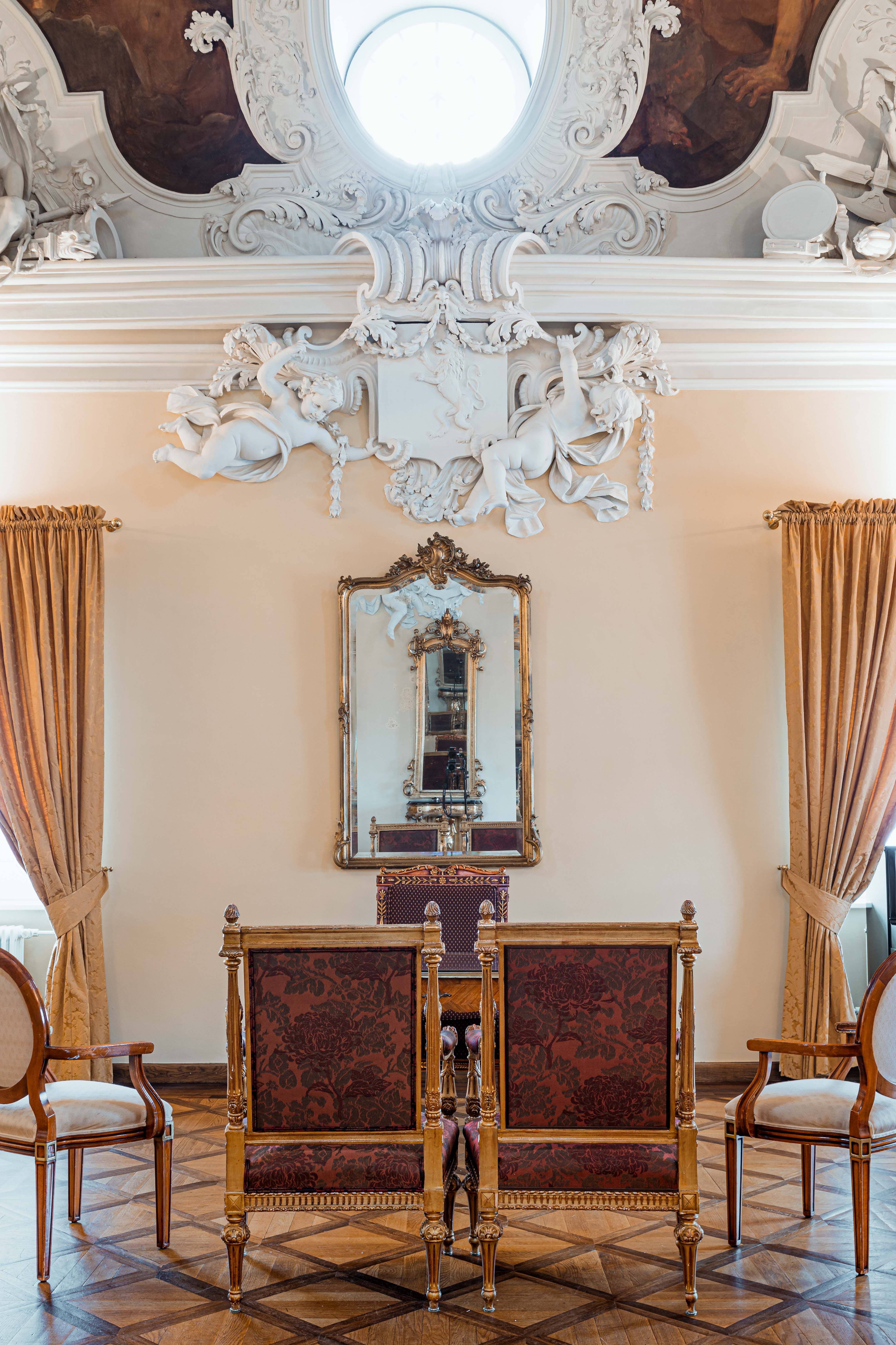 Historische Stühle im Salon mit Stukkaturen an der Decke