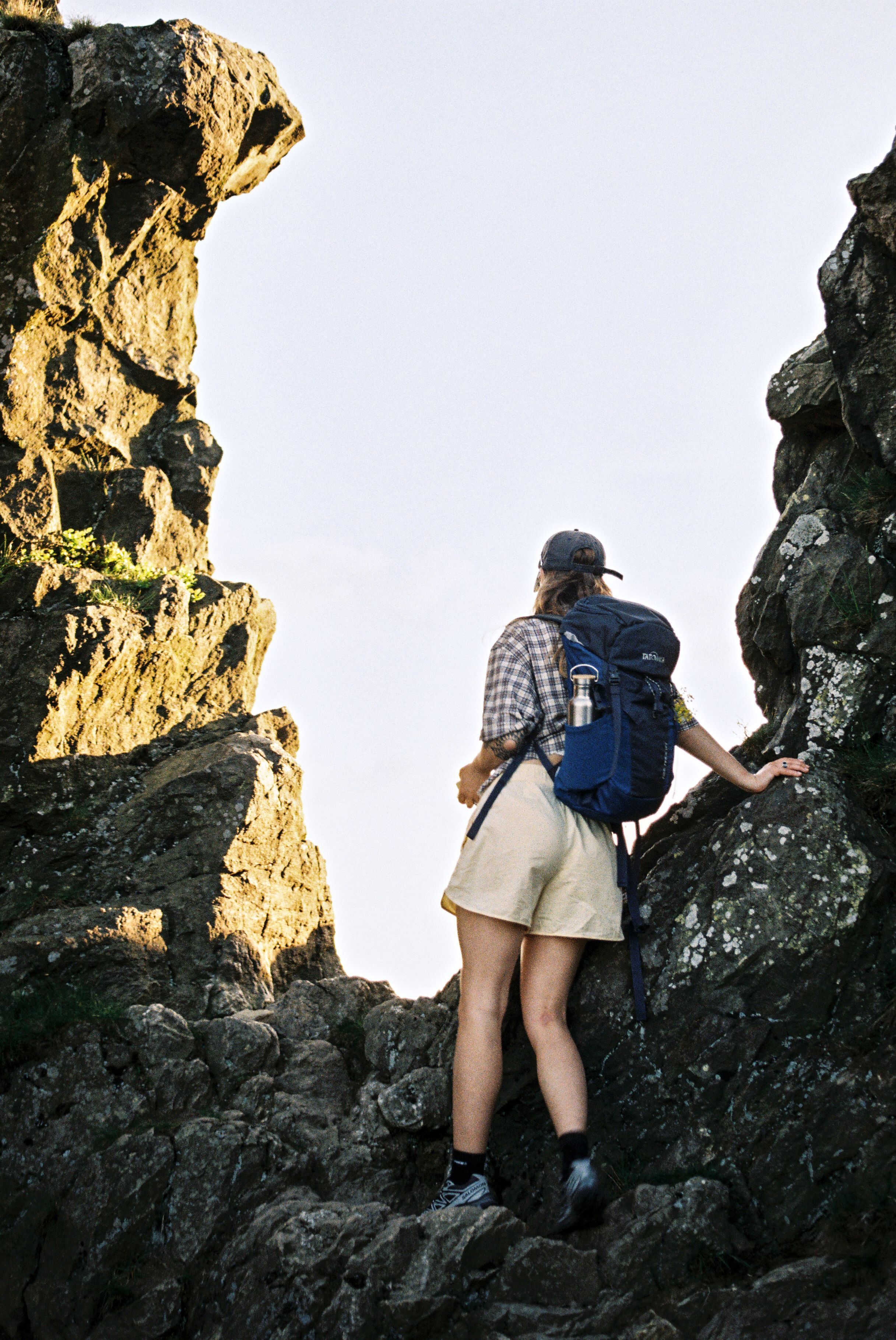 Ein Wanderer steht in die ferne blickend zwischen zwei Felsen auf Pfad der Bruchhauser Steine.
