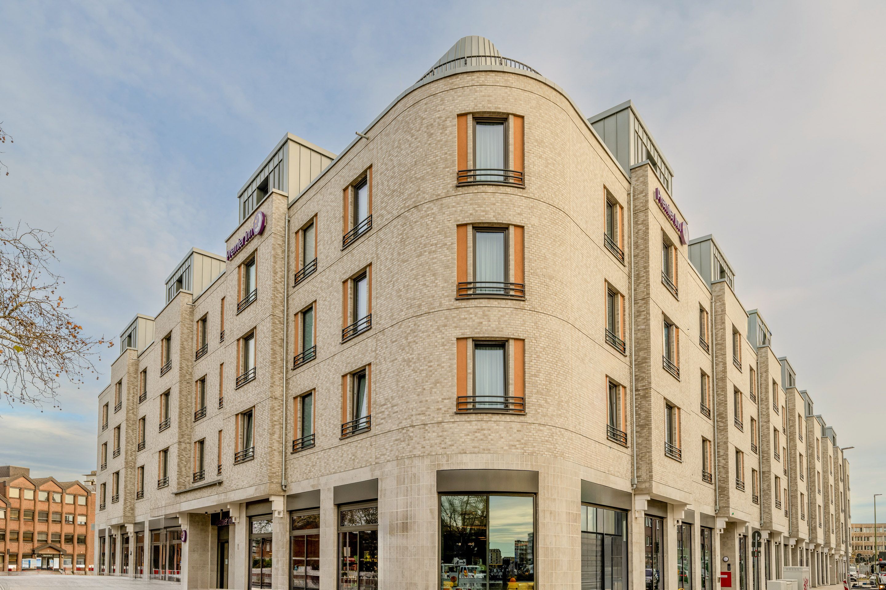 Fassade eines modernen Hotels mit mehreren Stockwerken und großen Fenstern.