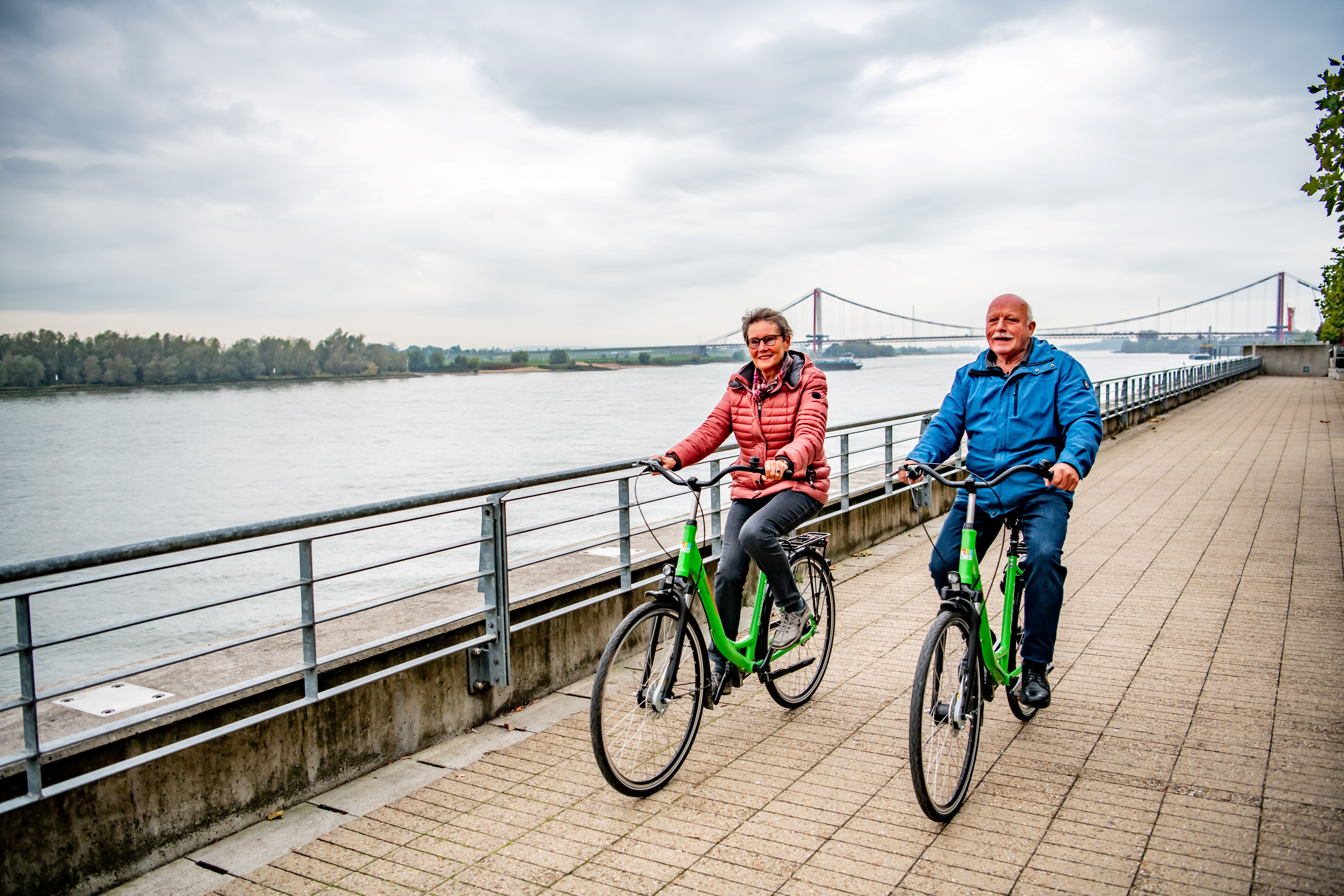 Zwei Radfahrende genießen das Rheinpanorama in Emmerich. Sie sind auf dem Hanseradweg unterwegs