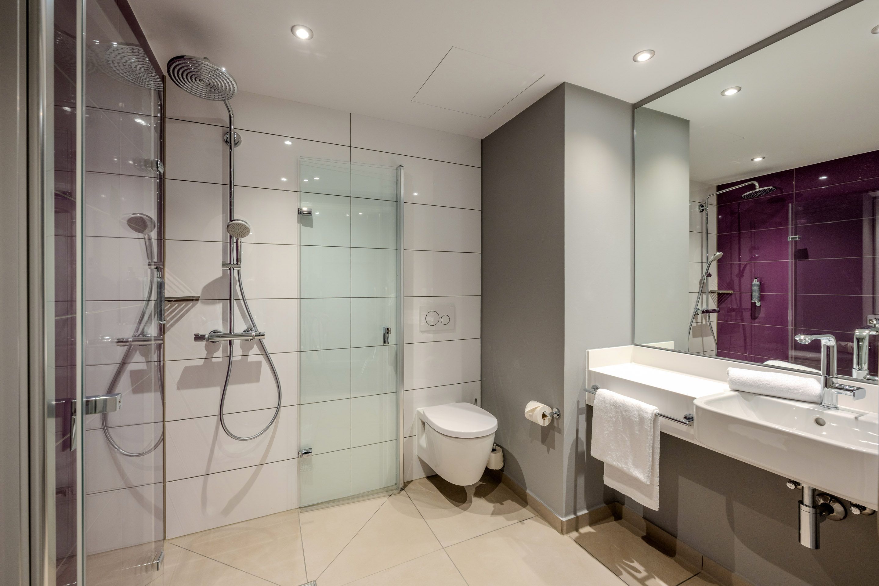 Modernes Badezimmer mit Dusche, Toilette und Waschbecken.
