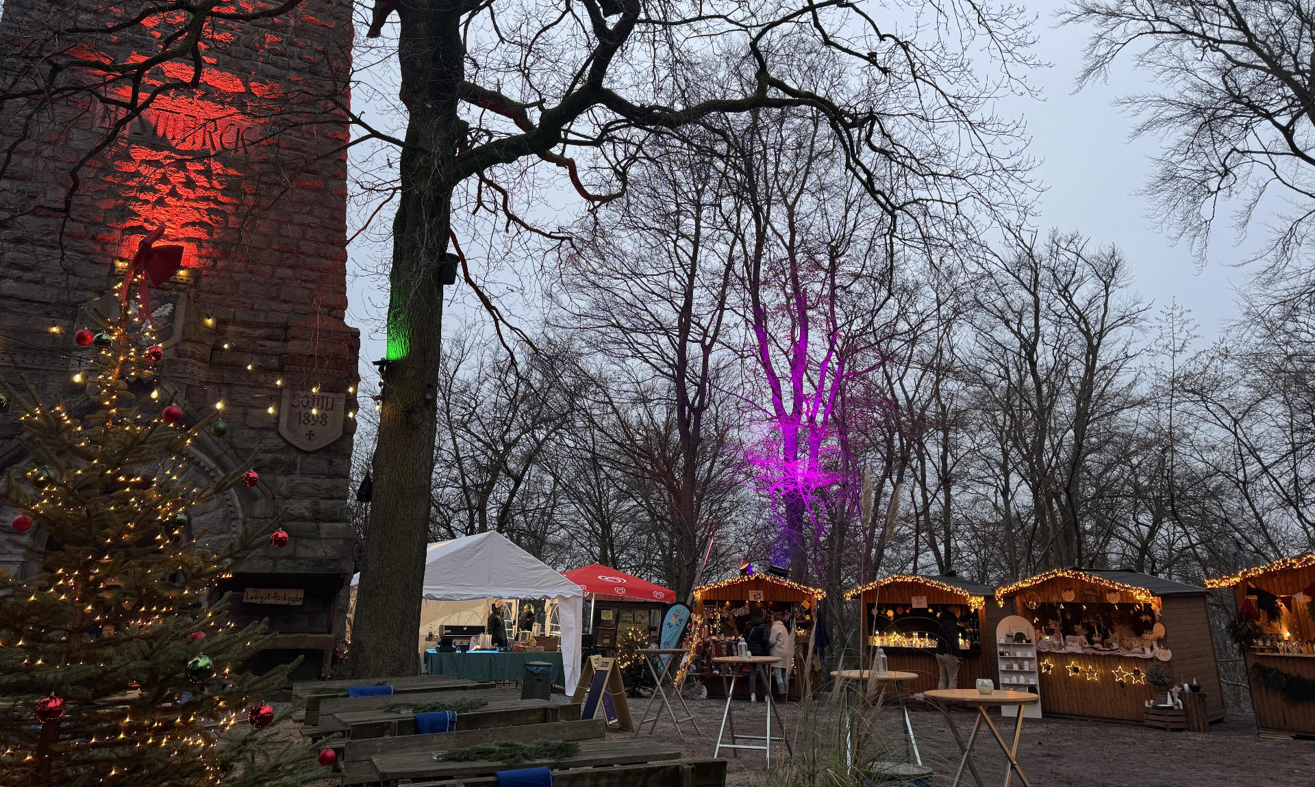 Der 3. Wintermarkt am Bismarckturm mit beleuchteten Ständen und einem geschmückten Weihnachtsbaum.