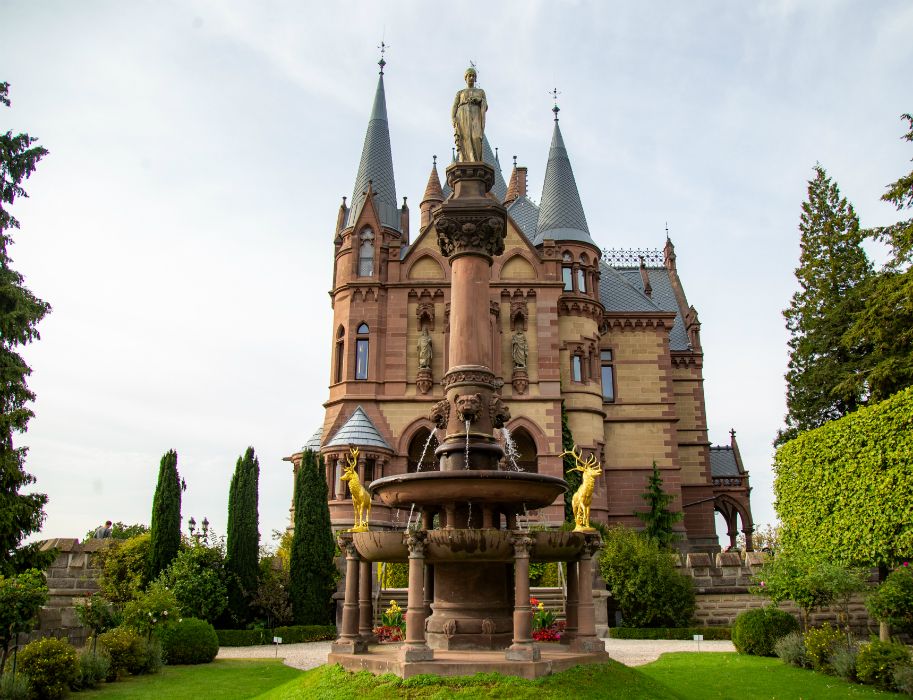 Schloss Drachenburg mit Brunnen im Vordergrund.