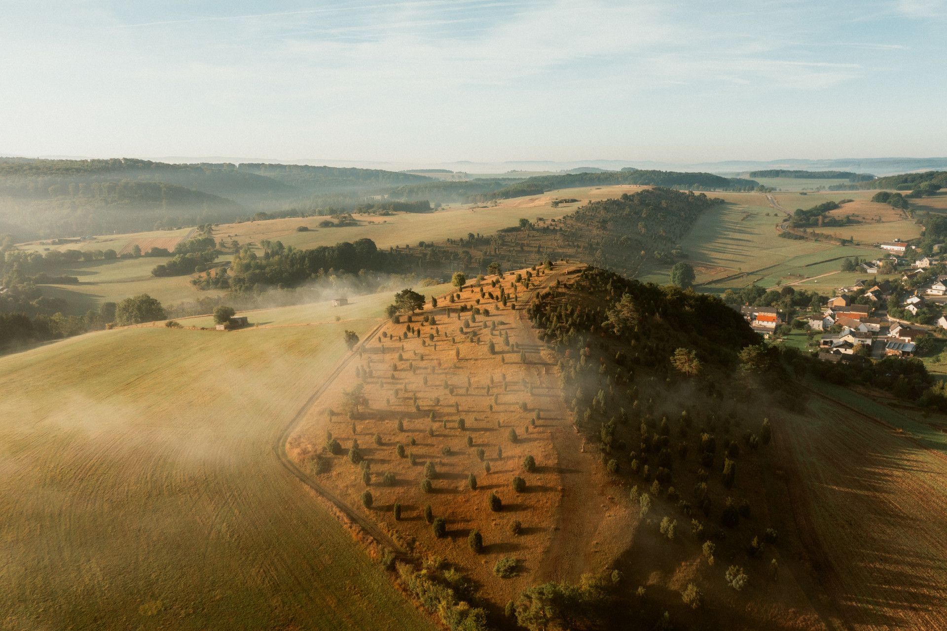 Luftaufnahme des Kalvarienbergs Alendorf mit Nebel und umliegender Landschaft.