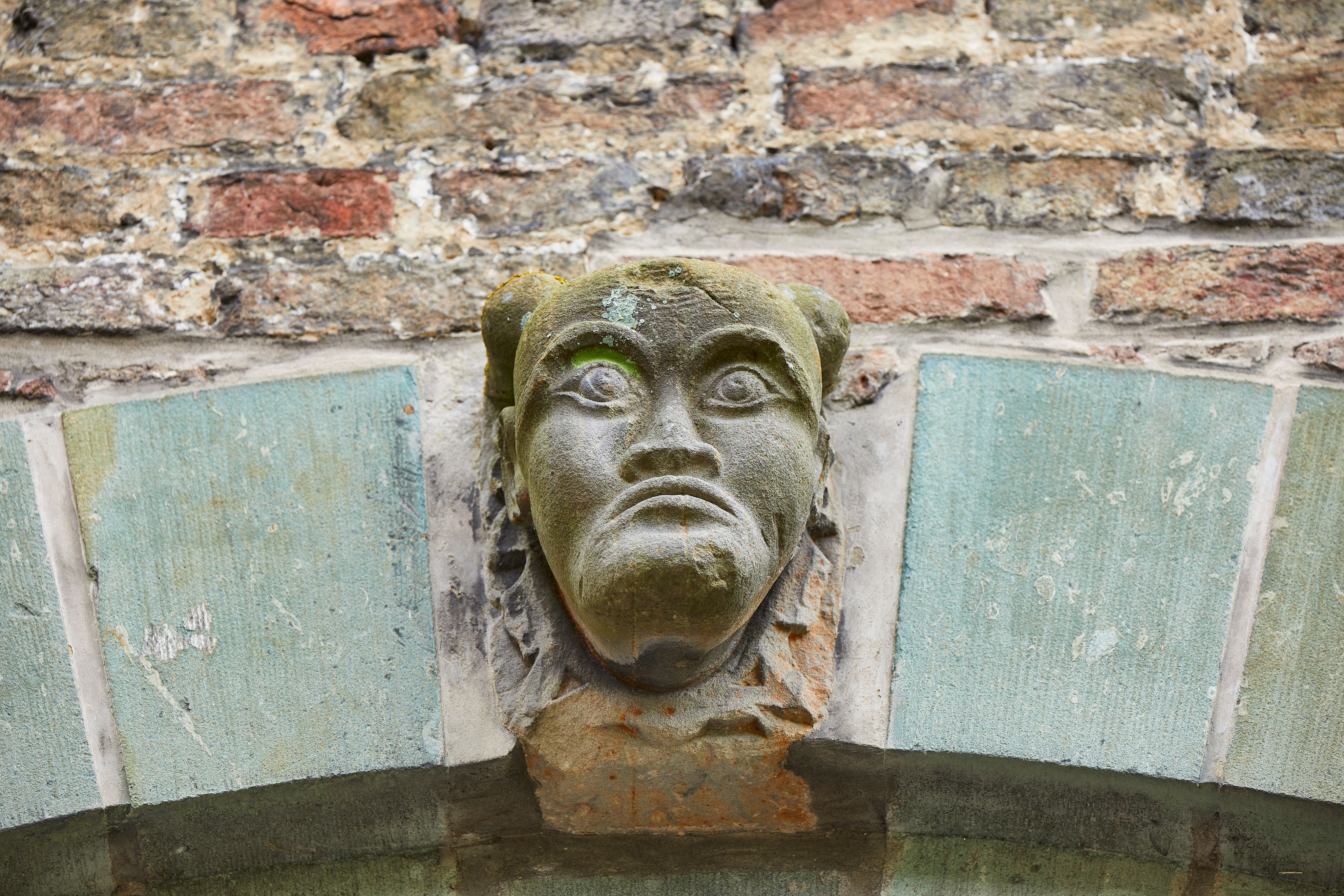Die Wände und Tore des Hauses Assen sind mit Masken, Löwenköpfen, Wappen und Inschriften verziert