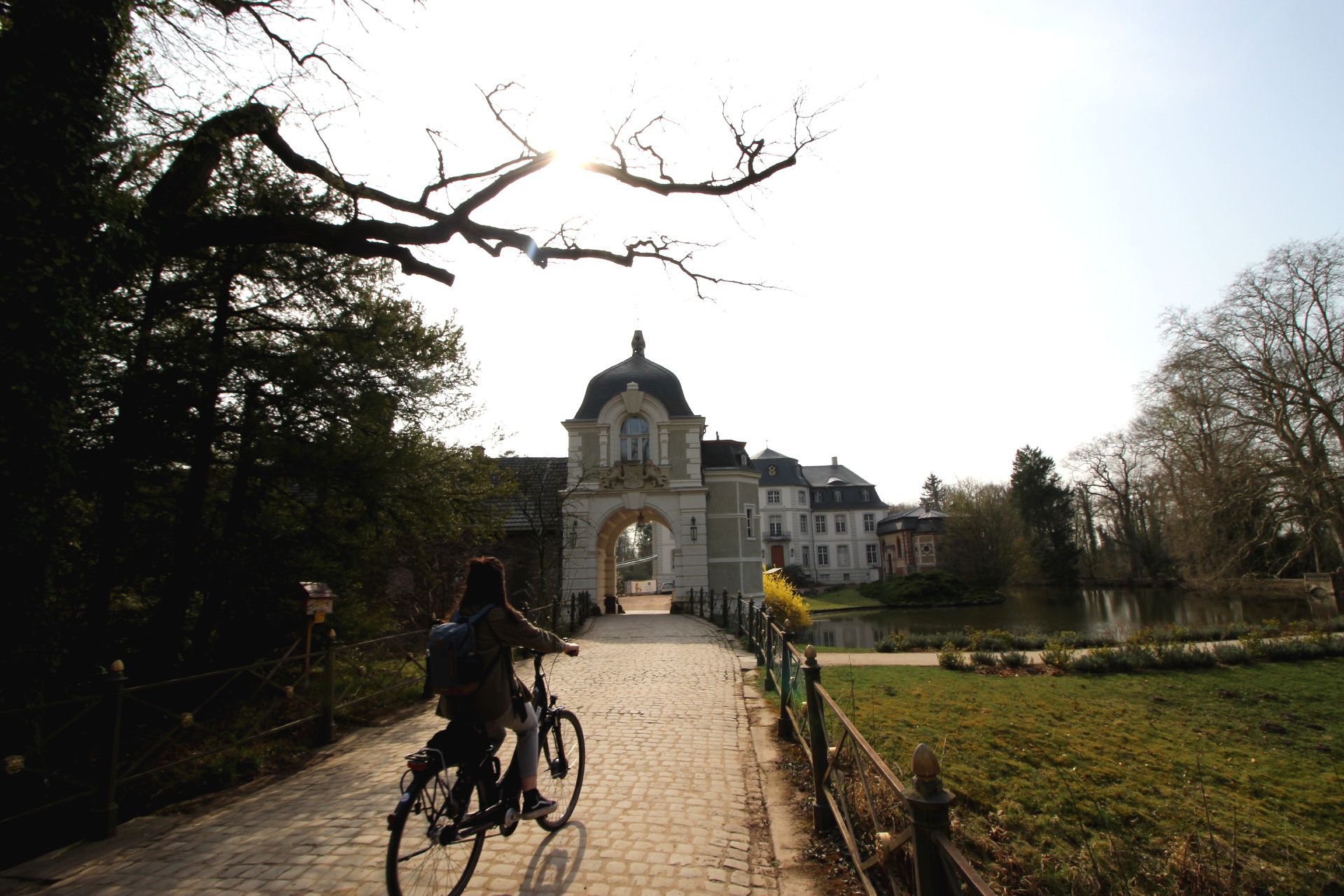 Eine Person begibt sich mit dem Fahrrad zum Schloss Türnich