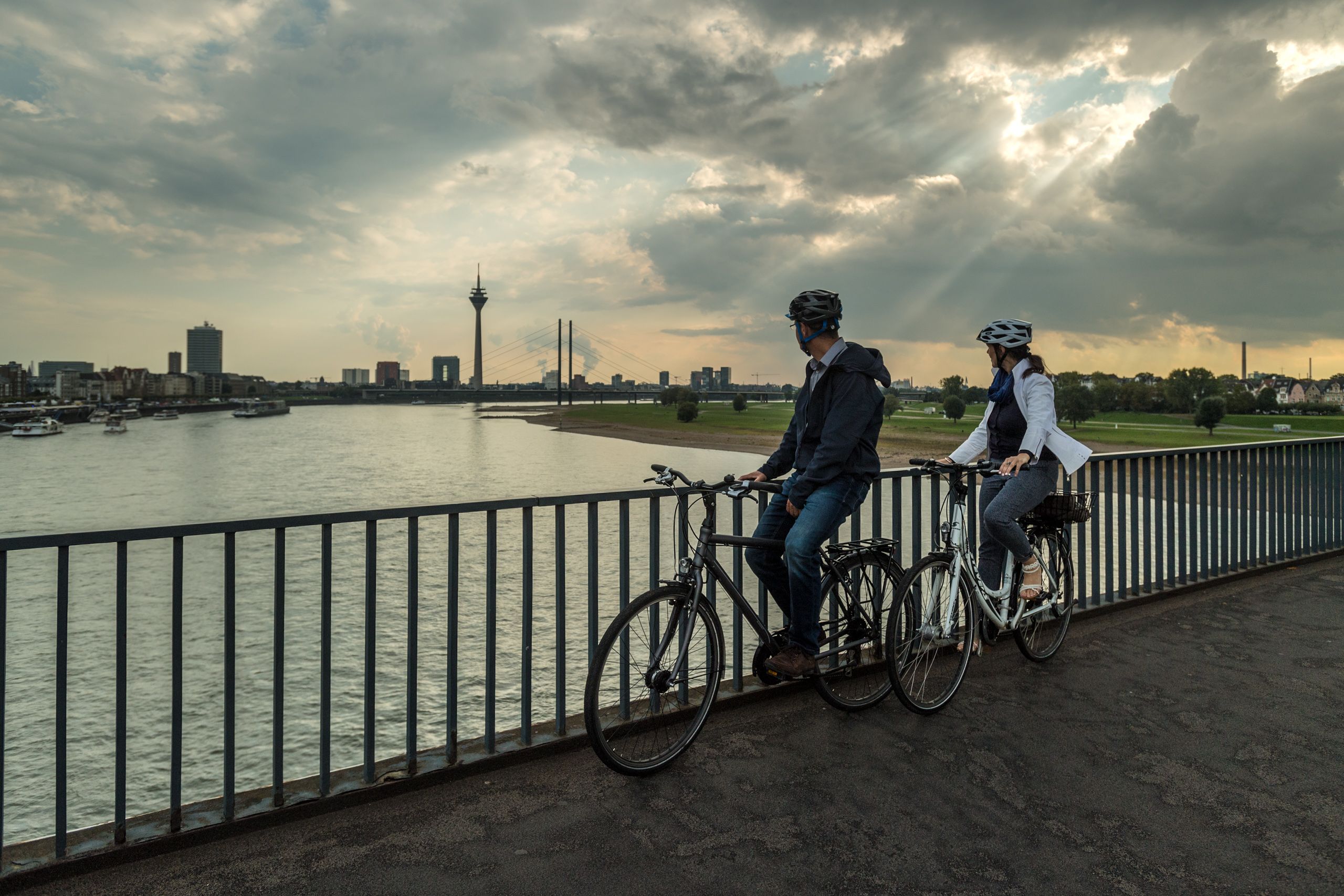 Zwei Radfahrer blicken auf den Rhein.