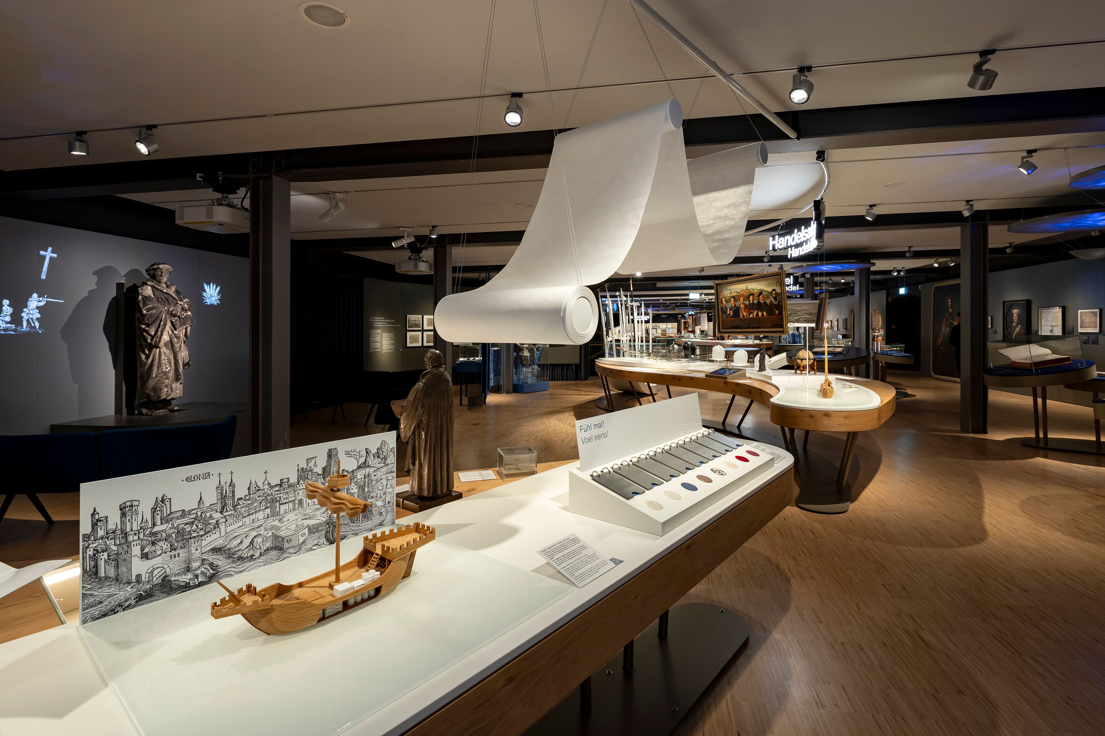 Innenansicht einer Ausstellung mit historischen Exponaten und interaktiven Elementen.