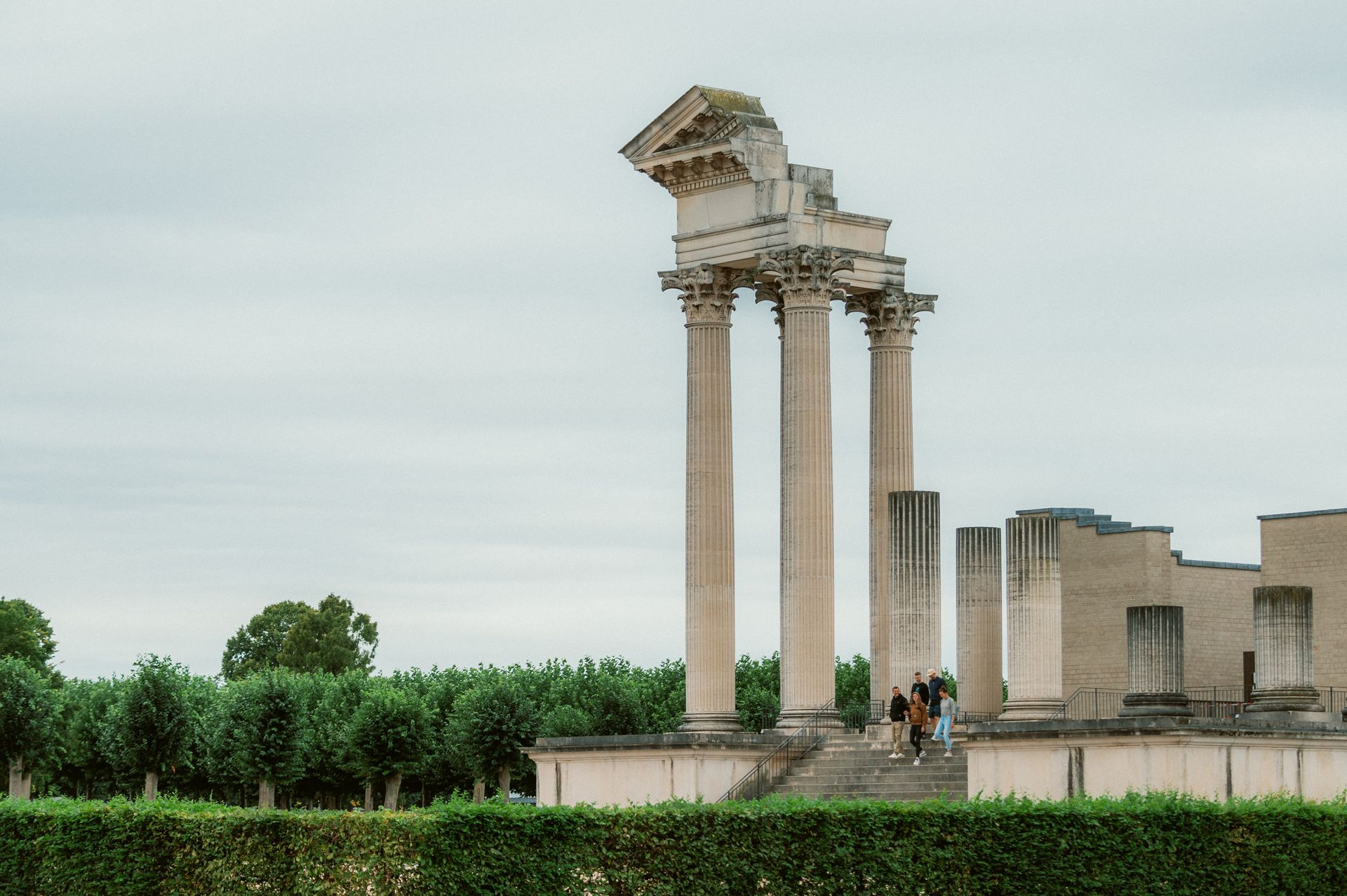 Römische Säulen im LVR-Archäologischen Park Xanten mit Besuchern auf einer Treppe.