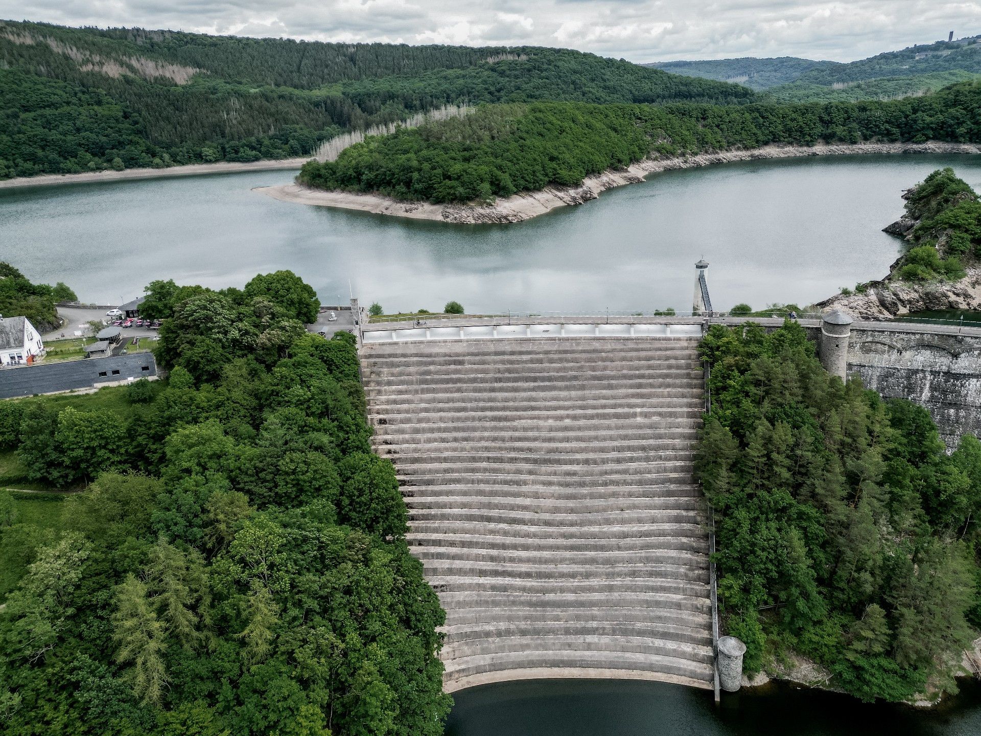 Luftaufnahme der Urfttalsperre in der Eifel mit umgebendem Wald und Wasser.