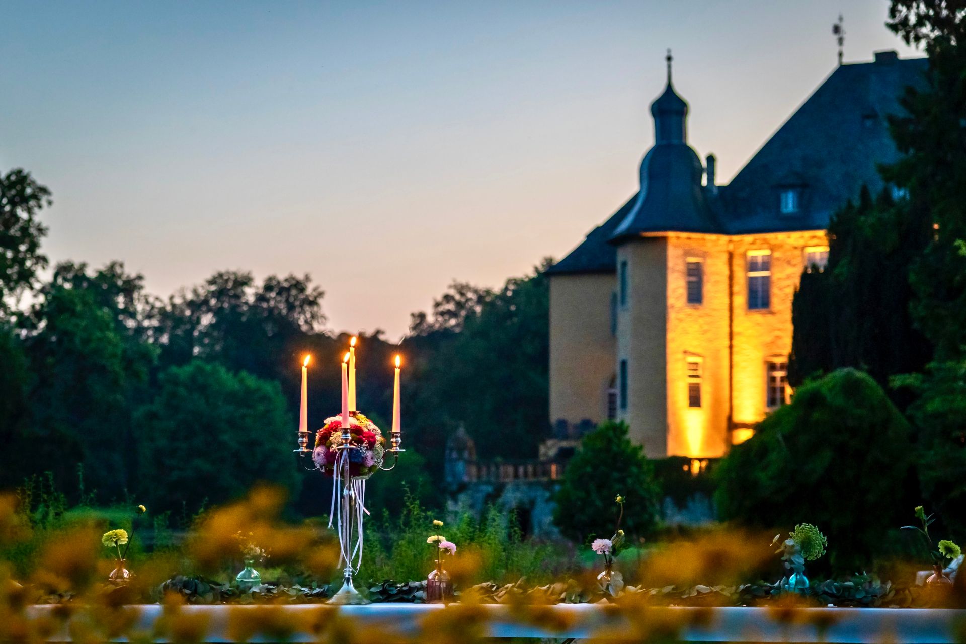 Kerzenleuchter spenden Licht und sorgen in der Dämmerung für die passende Atmosphäre an der großen Tafel