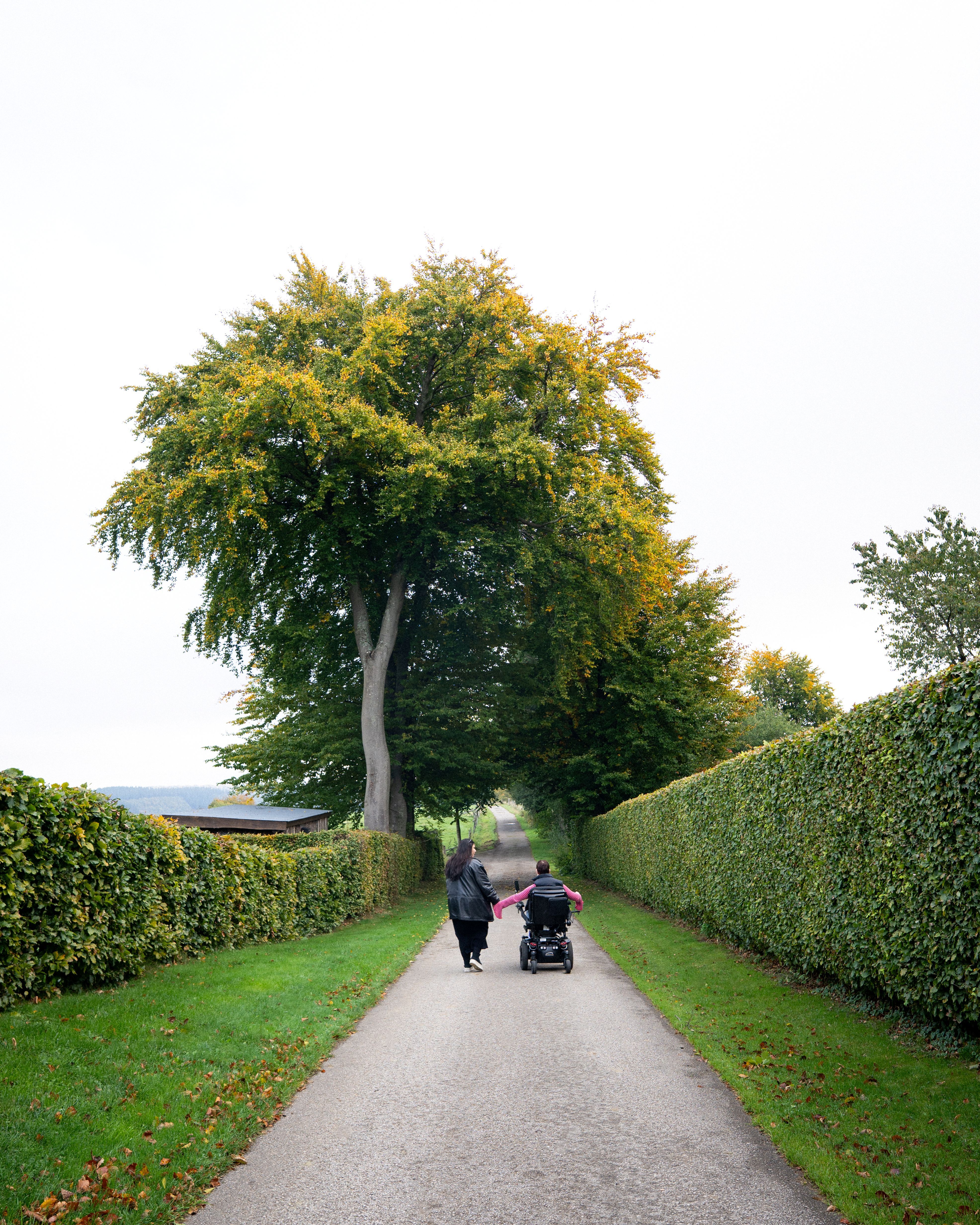 Zwei Freundinnen spazieren Hand in Hand auf dem Höfener Heckenweg
