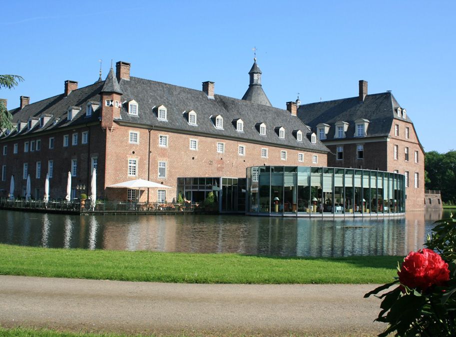 Bei einem Spaziergang durch die Parklandschaft der Wasserburg Anholt sind einzelne Gebäudeteile wie das Restaurant sehr gut auszumachen