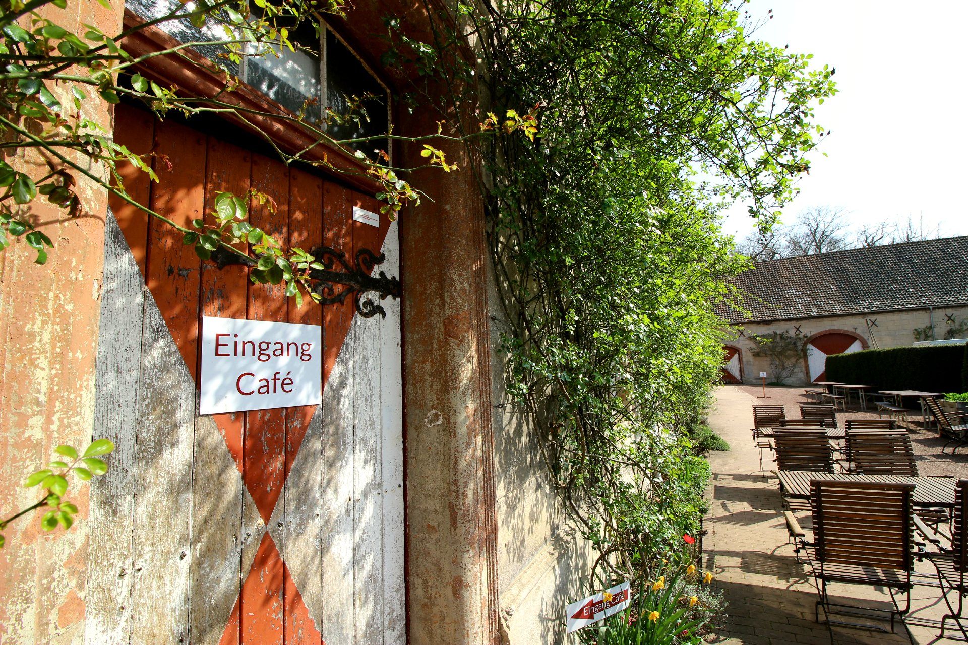 Die von Pflanzen umgebene Eingangstür führt zu einem Café am Schloss Türnich