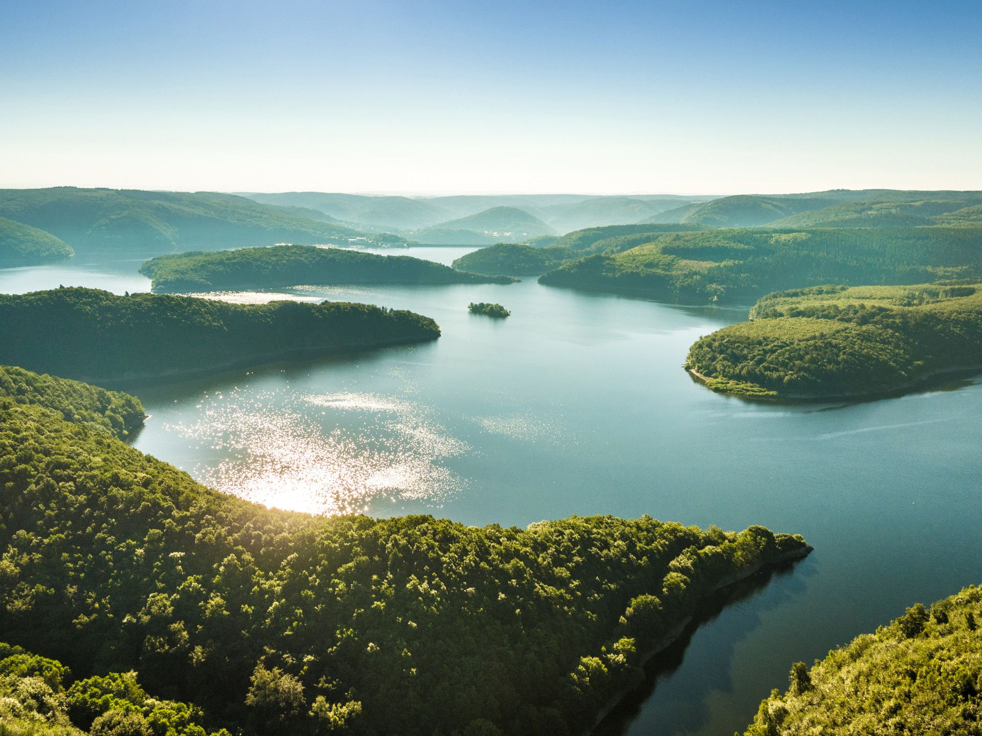 Blick auf von Wäldern umgebenen See im Sonnenlicht