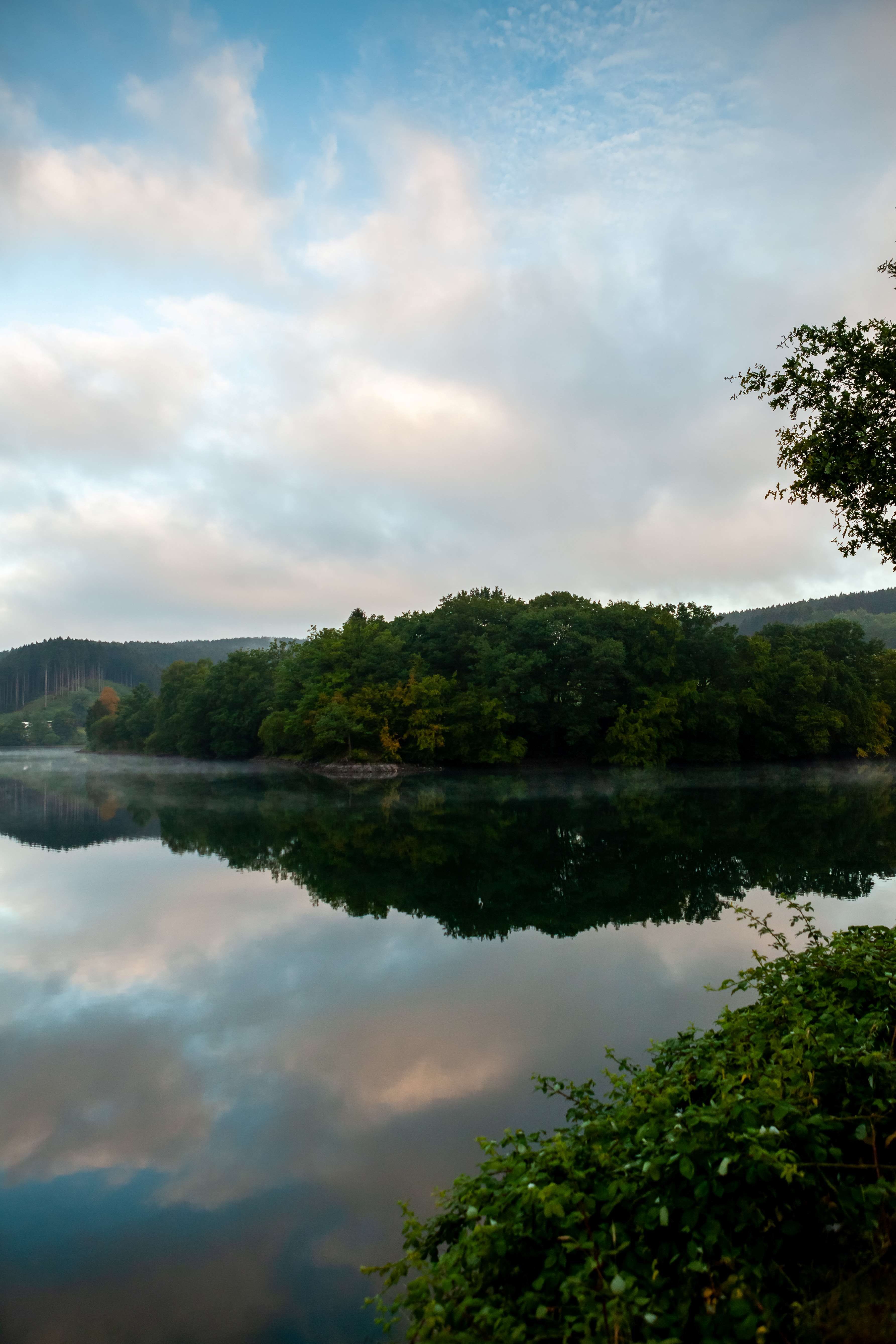 Im See spiegeln sich Himmel und Wolken
