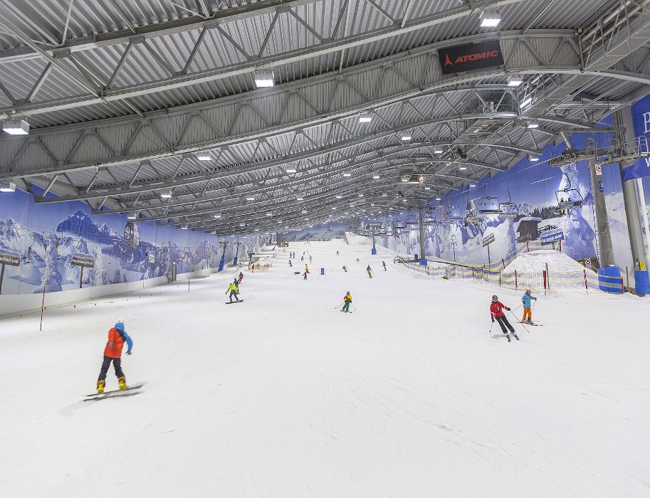Innenansicht einer Skihalle mit Skifahrern auf der Piste.