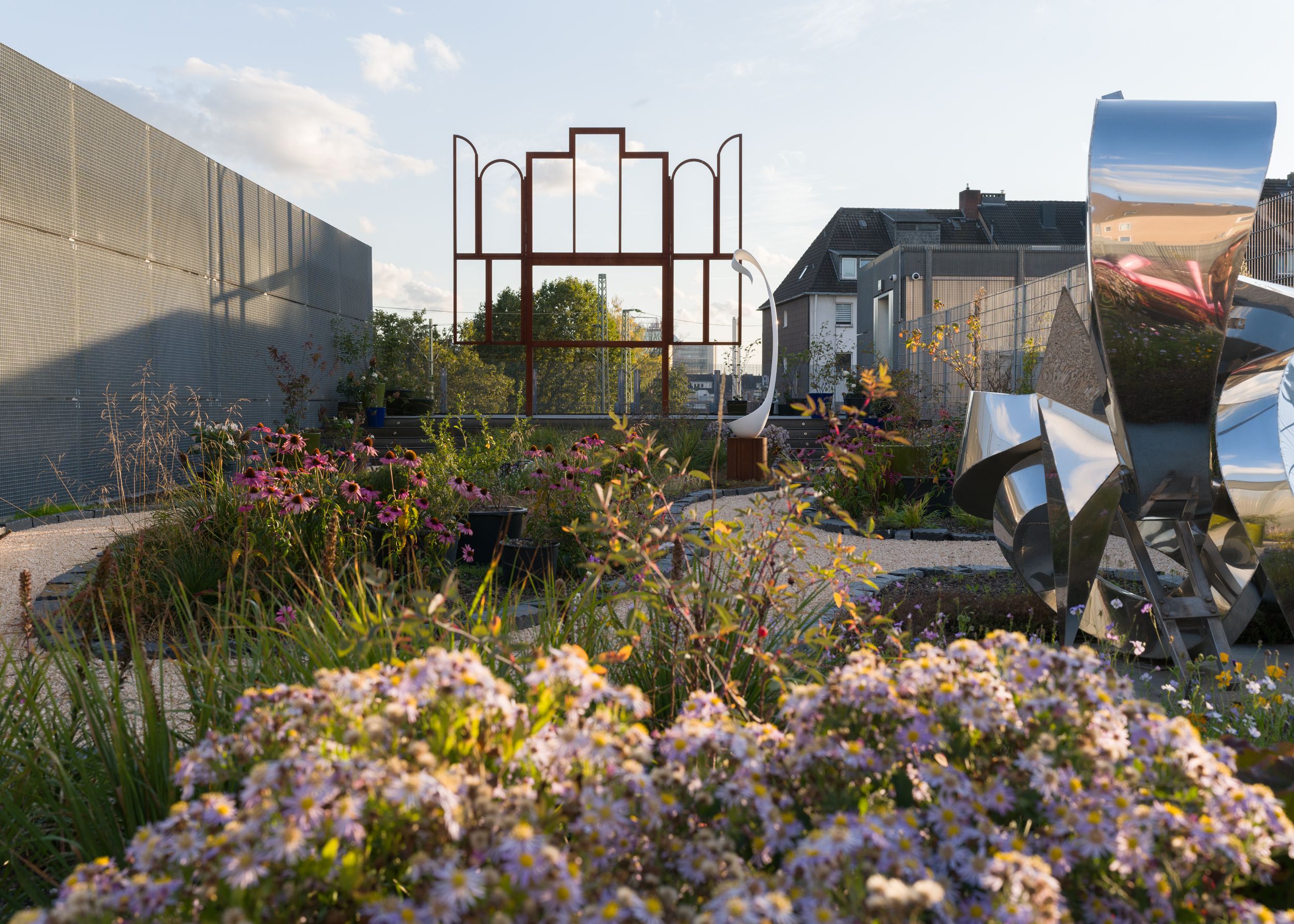 Im Dachgarten der Sammlung Philara blühen farbenfrohe Blumen zwischen Kunst und Großstadtflair.