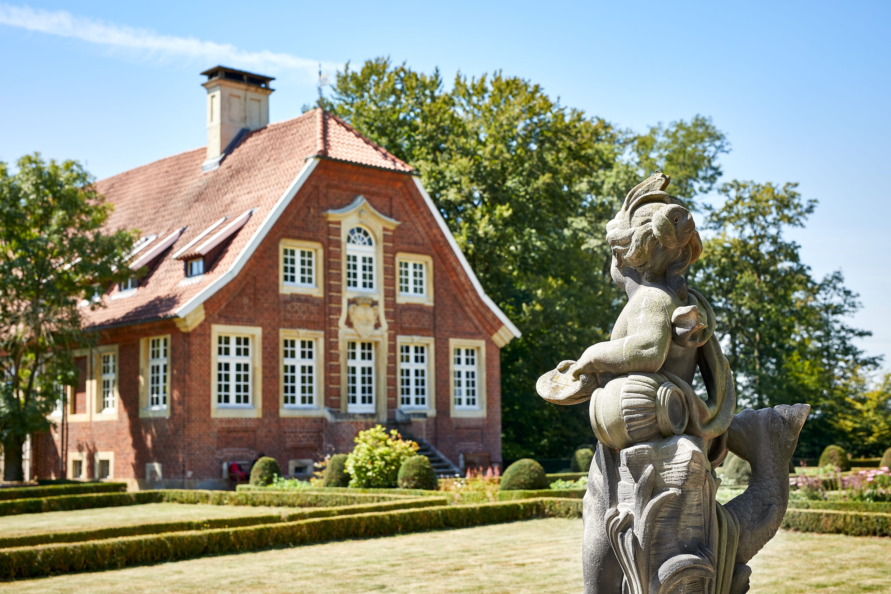 Haus Rüschhaus mit Skulptur im Vordergrund