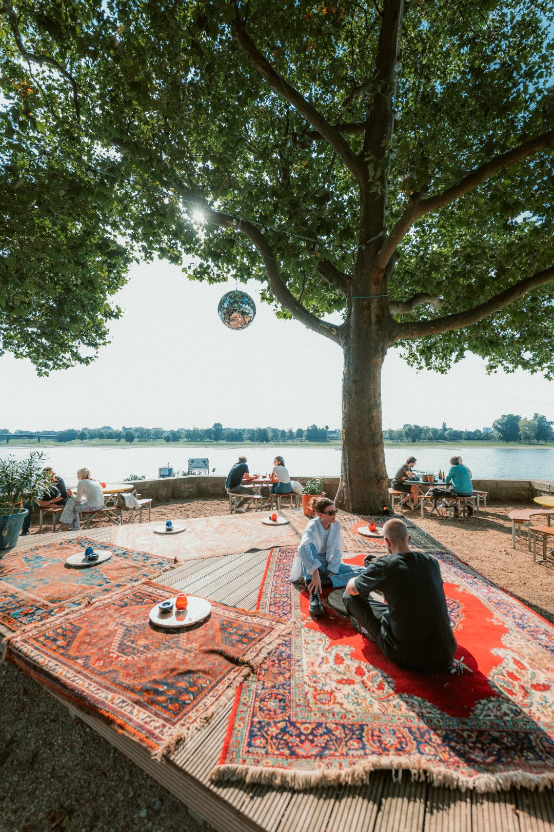 Sitzgelegenheiten am Wasser unter Baum im Three Little Birds 
