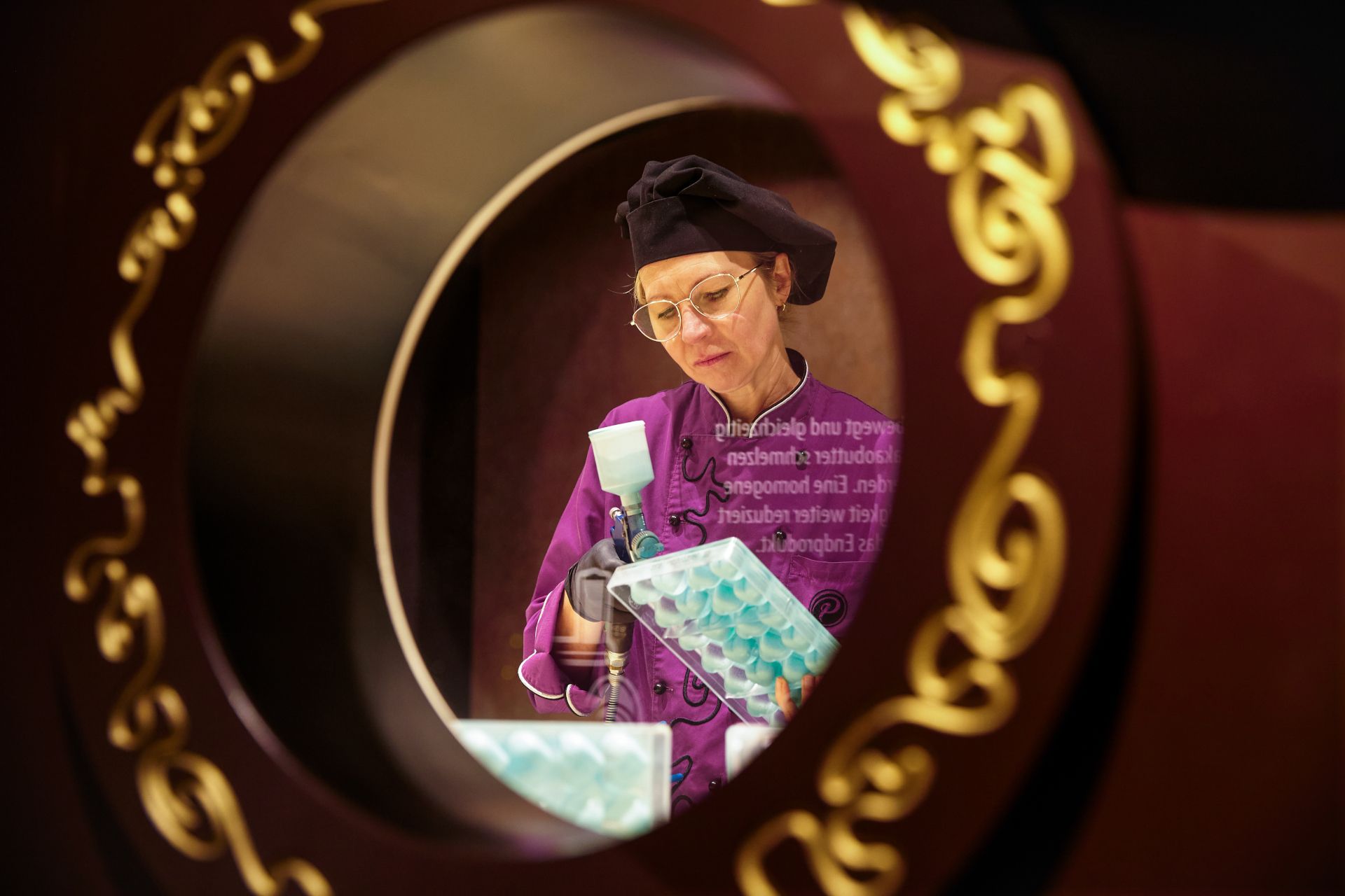 Gäste können Chocolatiers in PETERS SchokoWelt beim Herstellungsprozess von Pralinen über die Schulter schauen