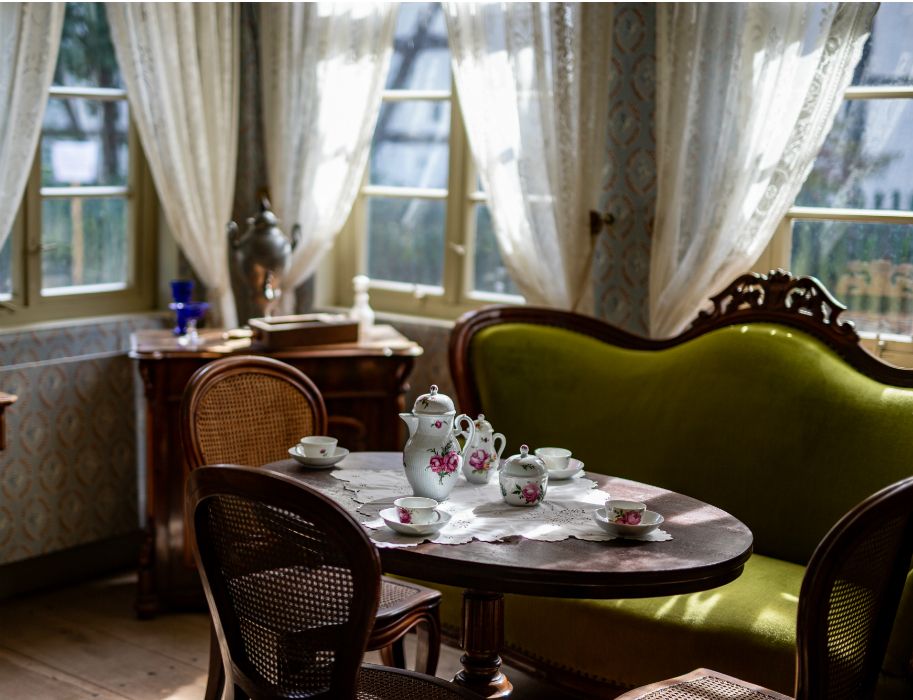 Bedeckter Tisch umgeben von Stühlen und einem Sofa