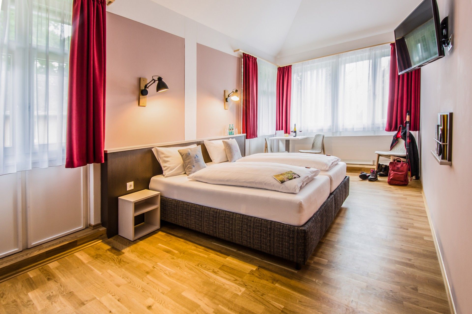 Doppelzimmer im JUFA Hotel Königswinter mit Doppelbett, Schreibtisch und Fernseher.