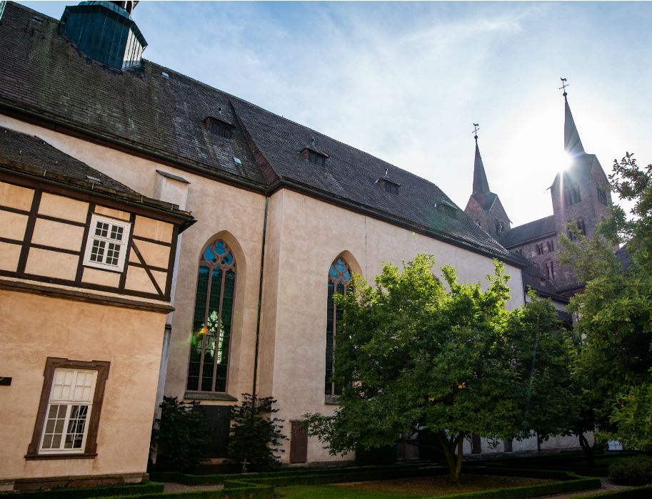 Außenansicht der ehemaligen Klosterkirche mit dem Westwerk und den Kirchtürmen im Hintergrund