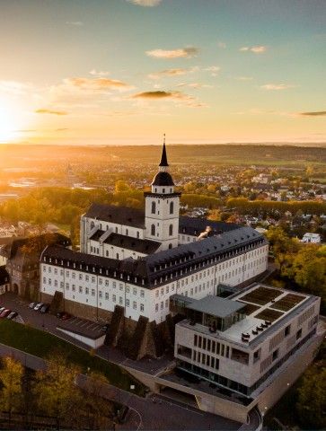 Luftaufnahme von Siegburg: das KSI auf dem Michaelsberg bei Sonnenuntergang mit Blick über die Stadt.
