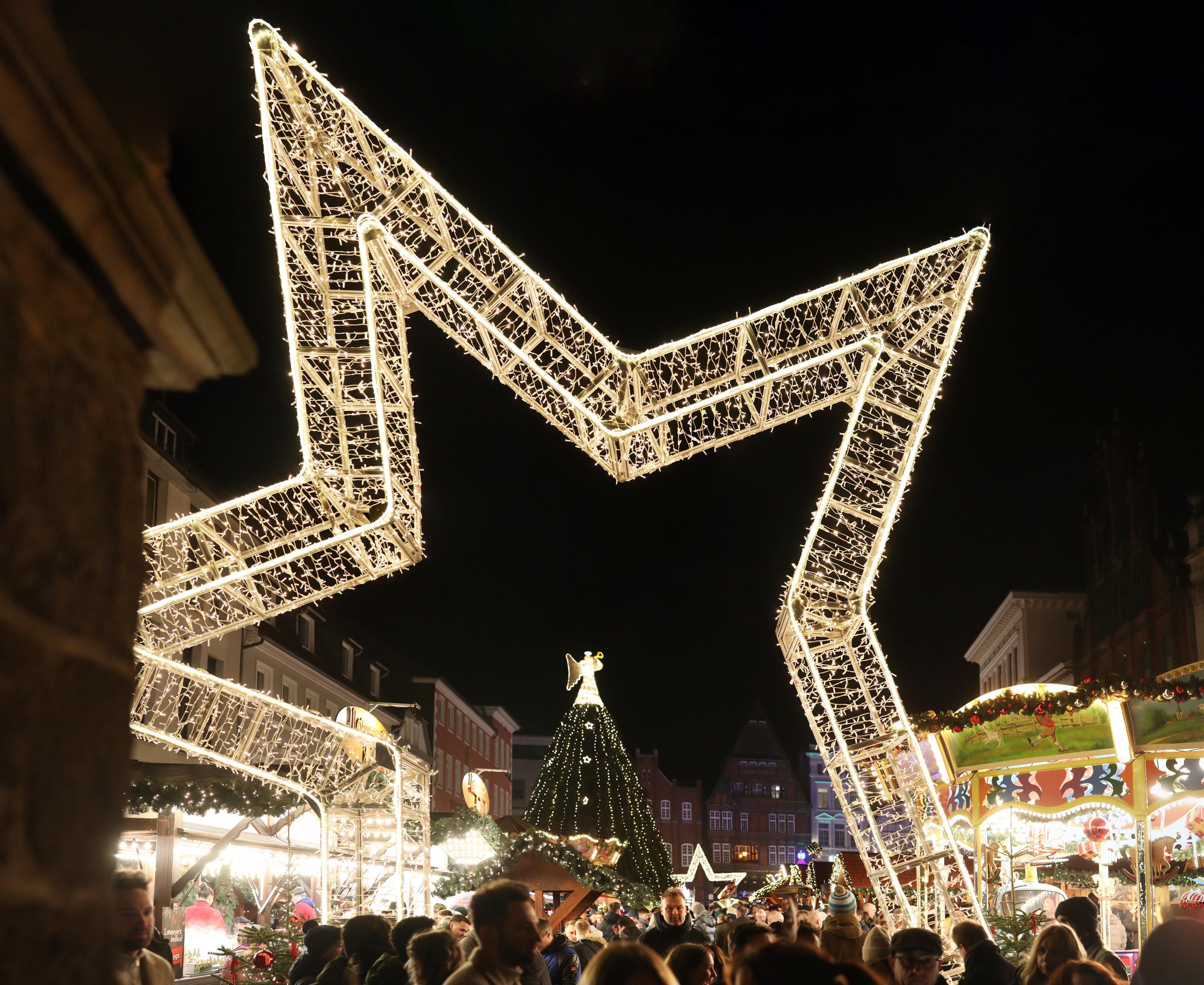 Mindener Weihnachtsmarkt 2026 mit großer beleuchteter Stern-Installation, Weihnachtsbaum und dichtem Besucherandrang bei Nacht.