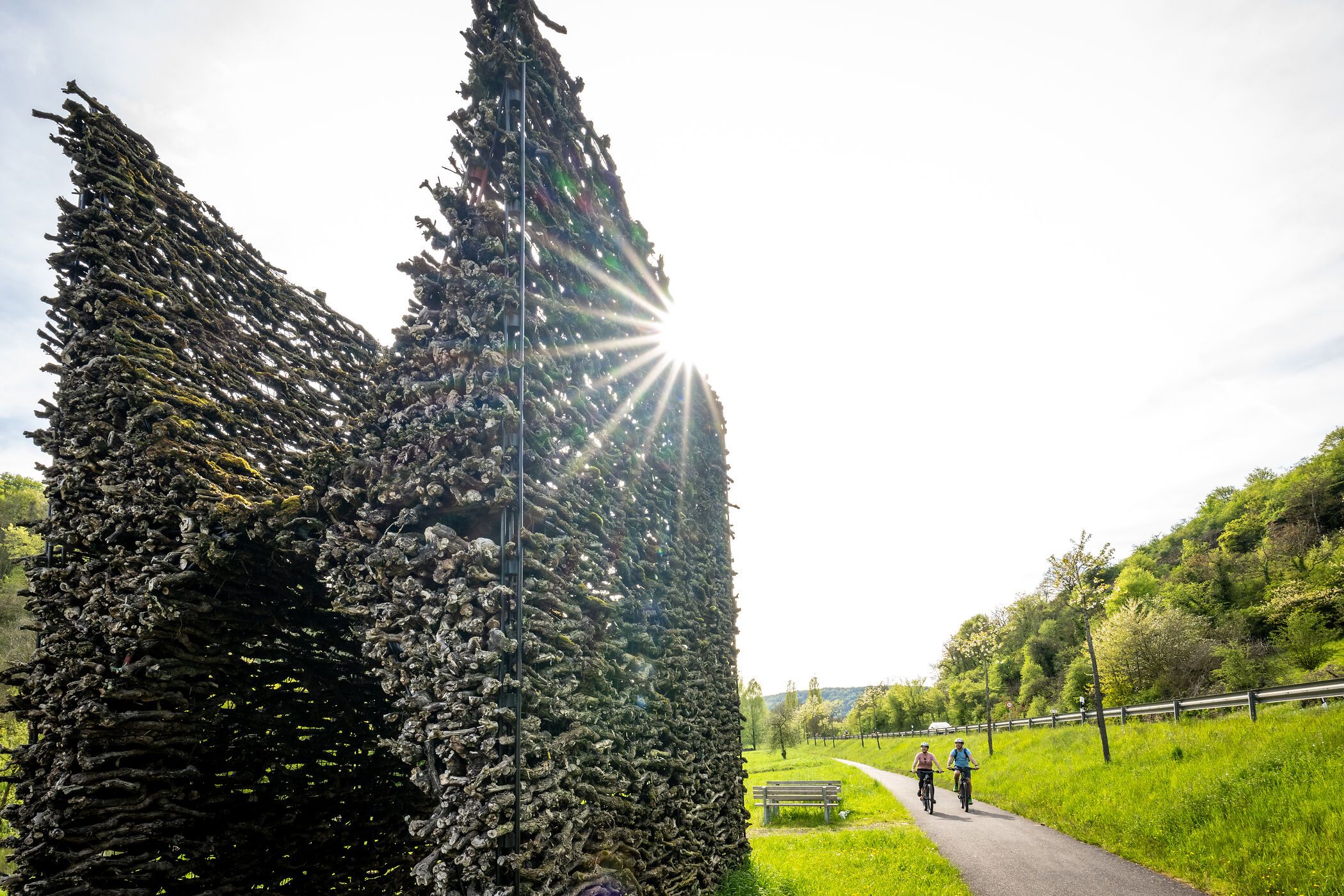Weintor am Sauer-Radweg mit Radfahrern auf einem Weg daneben.