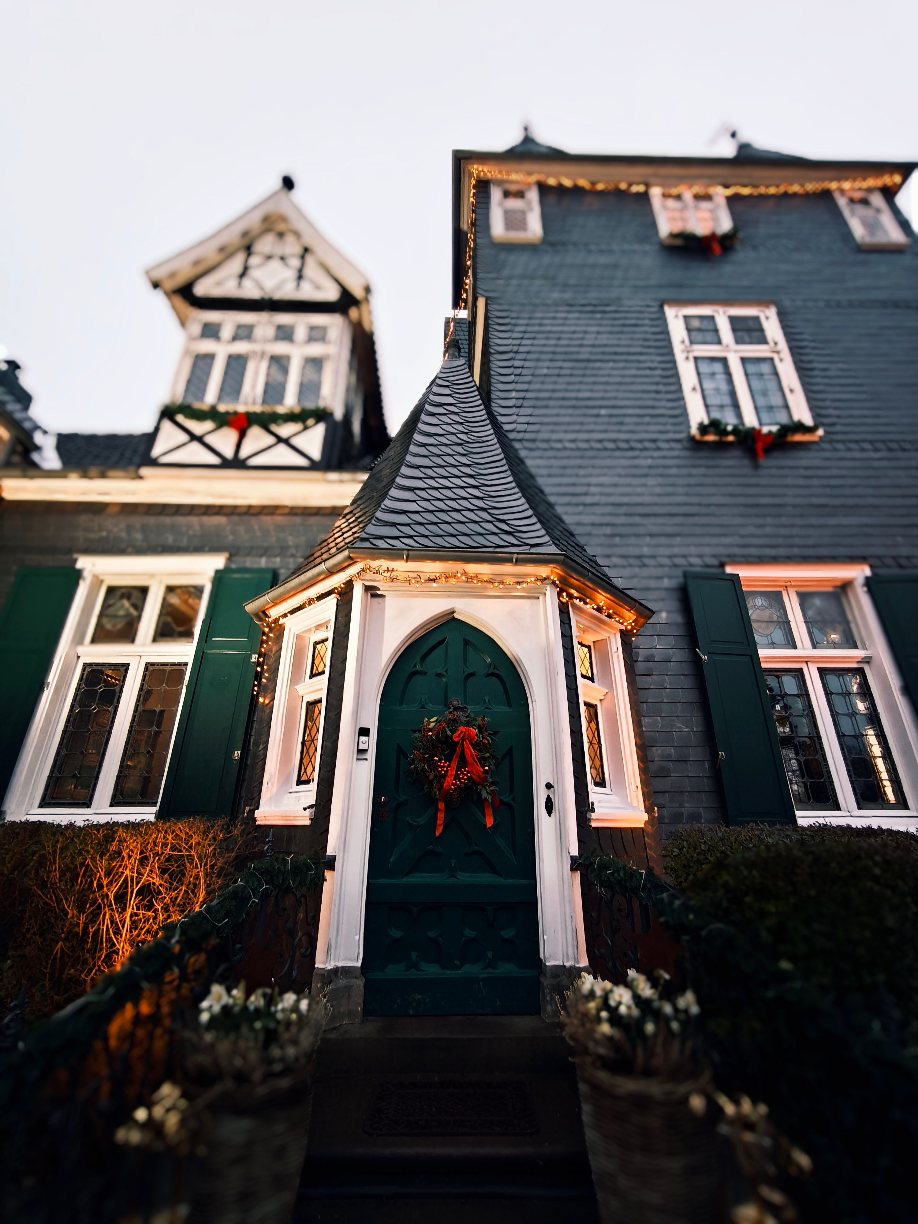 Geschmücktes Haus mit grünem Eingang, Weihnachtskranz und Lichterketten beim Grünewalder Adventstraum.