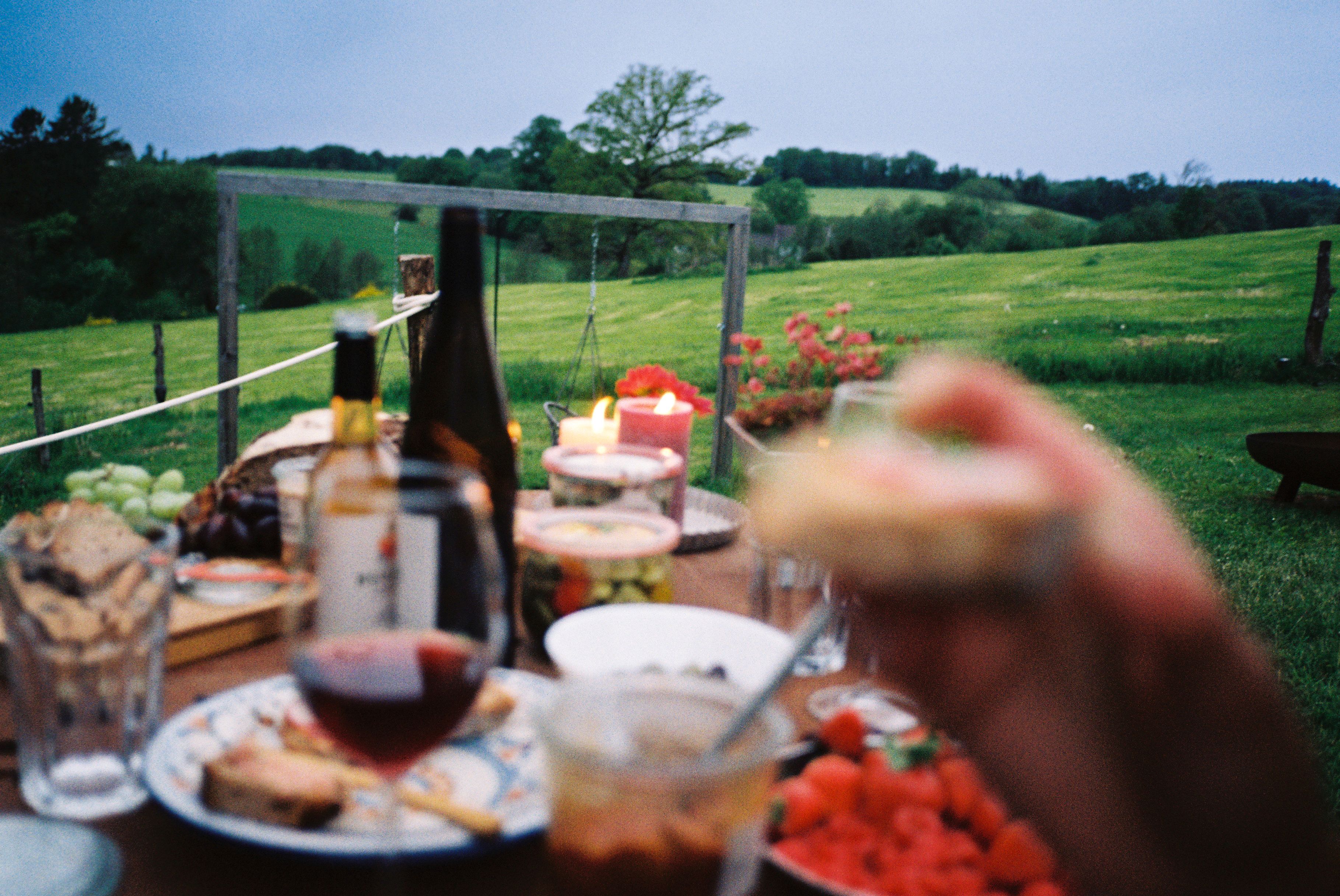 Molle&Korn, Henri Schade, Üppig gedeckter Picknick-Tisch mit grüner Landschaft im Hintergrund im Bergischen Land.