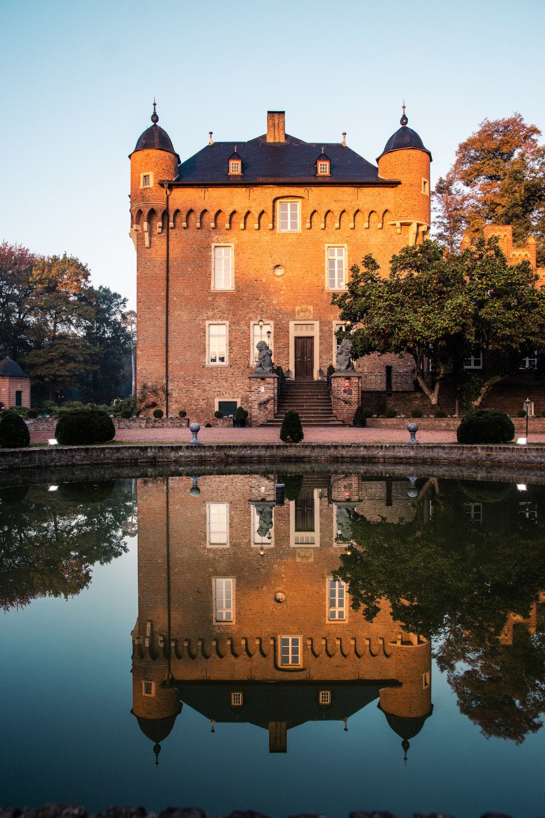Schloss mit zwei Türmchen spiegelt sich im Wasser