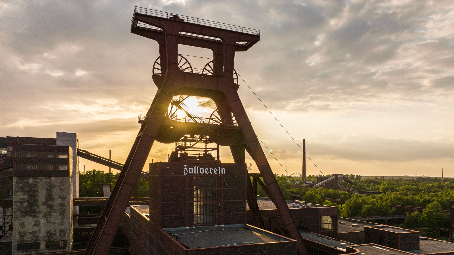 Förderturm im Abendlicht mit Bäumen im Hintergrund