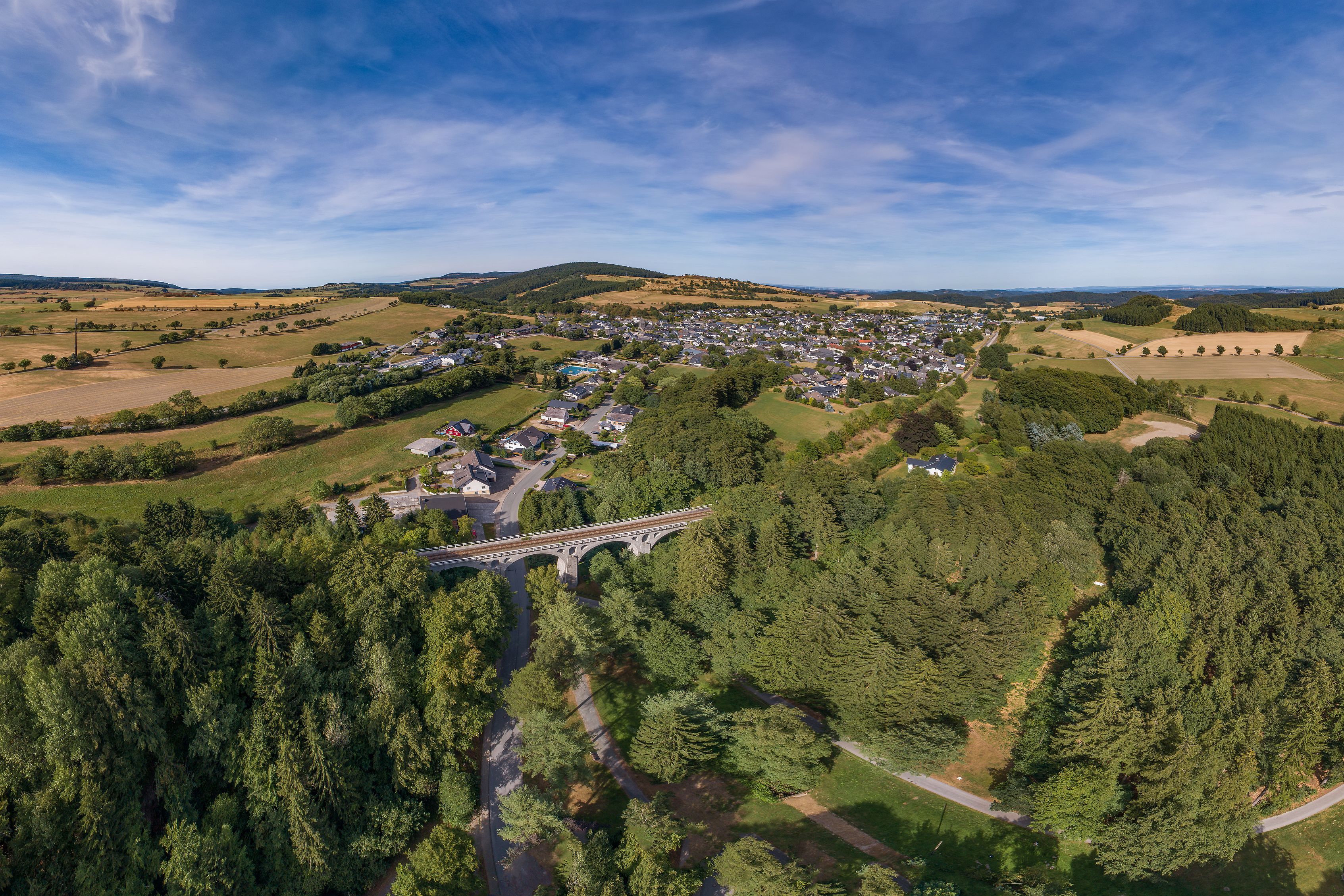 Luftaufnahme von Usseln mit Brücke und umliegender Landschaft.
