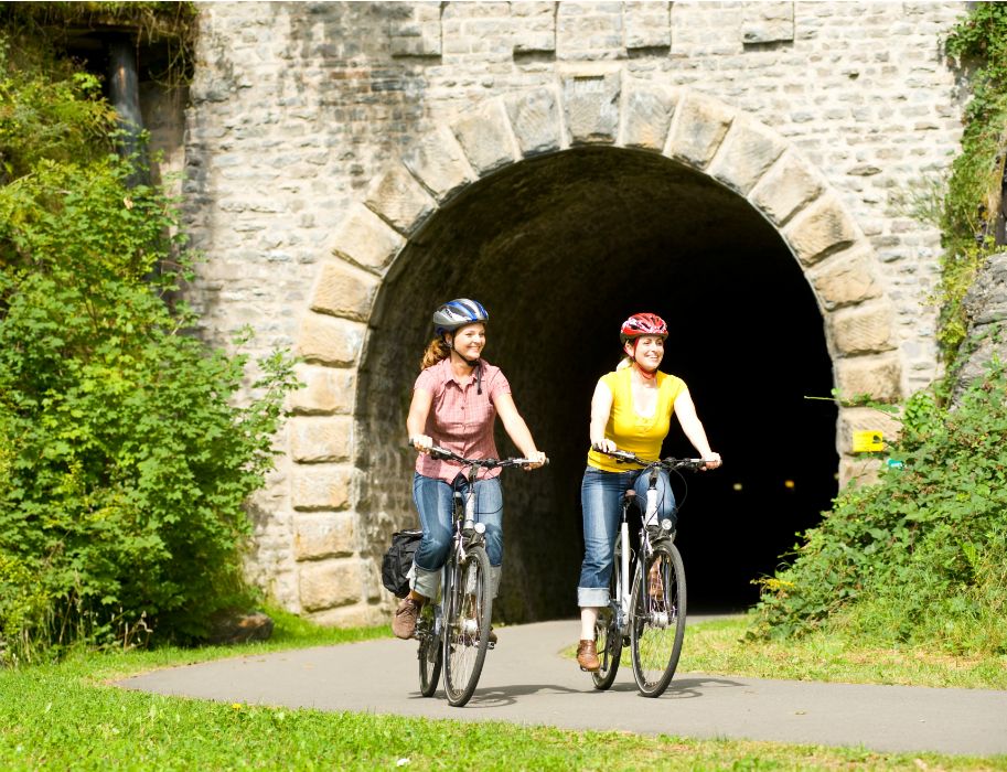 Zwei Frauen fahren mit Fahrrädern aus einem Tunnel auf dem Enz-Radweg.