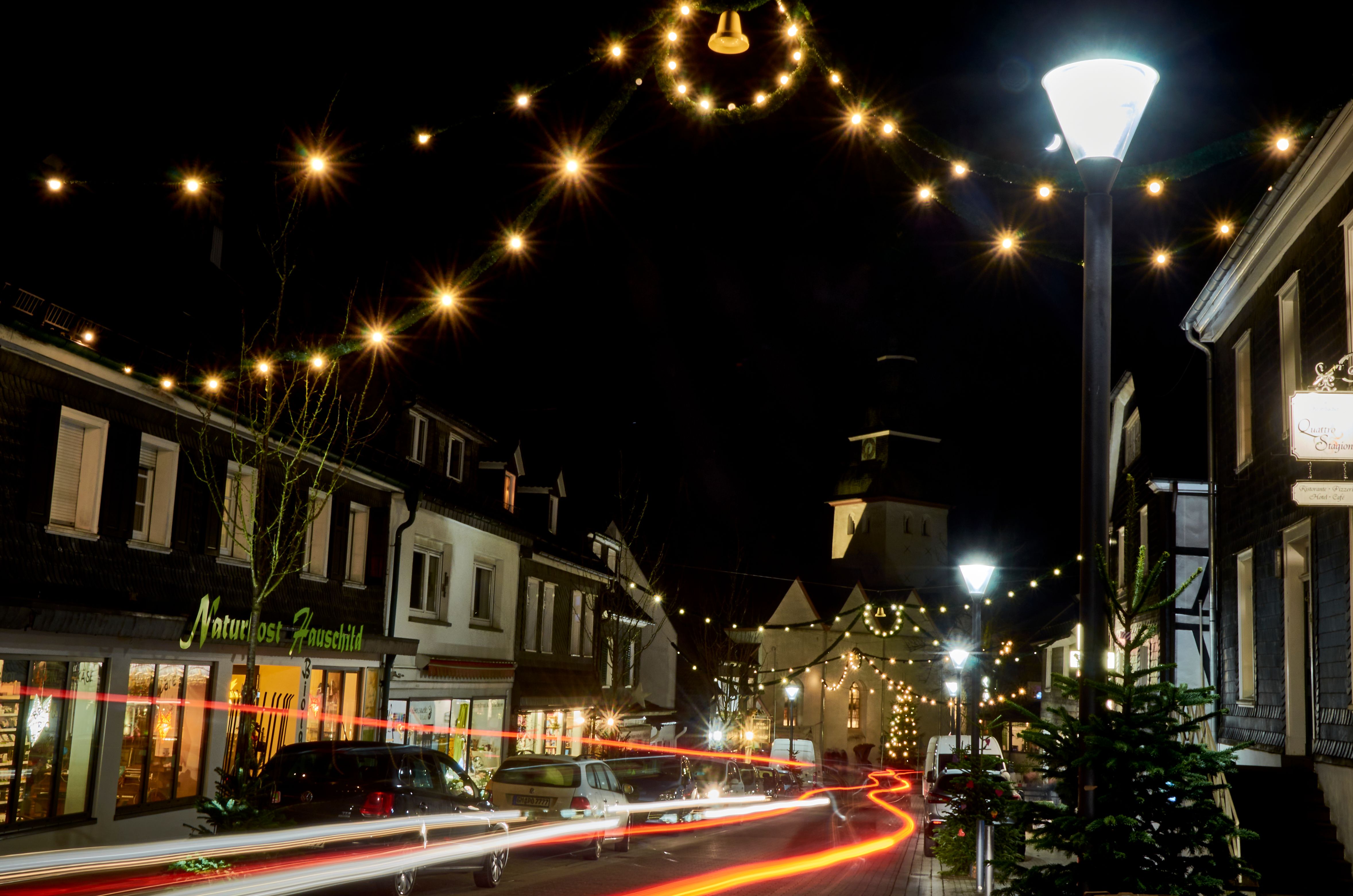 Weihnachtlich beleuchtete Straße in Nümbrecht bei Nacht mit Lichterketten.