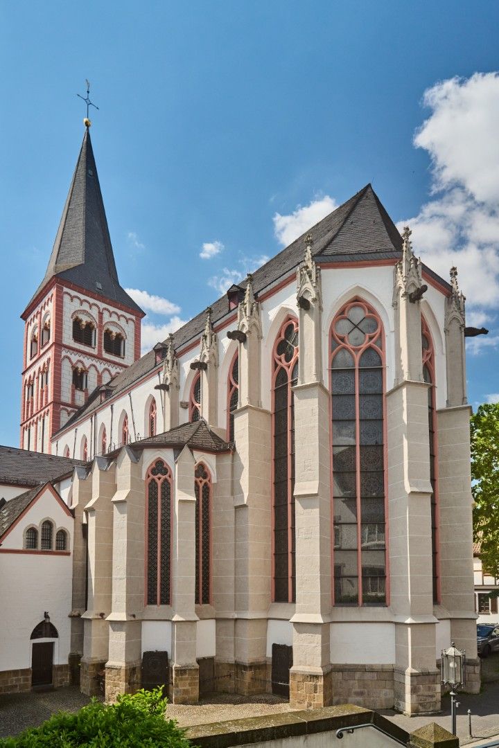 Die Kirche Sankt Servatius in Siegburg mit hohem Turm, gotischen Fenstern und blauem Himmel.
