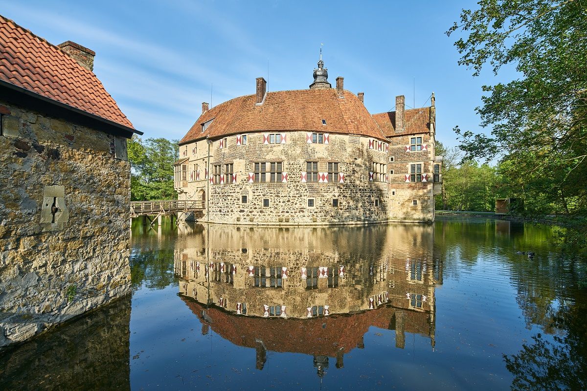 Mittelalterliche Wasserburg  spiegelt sich im Wasser