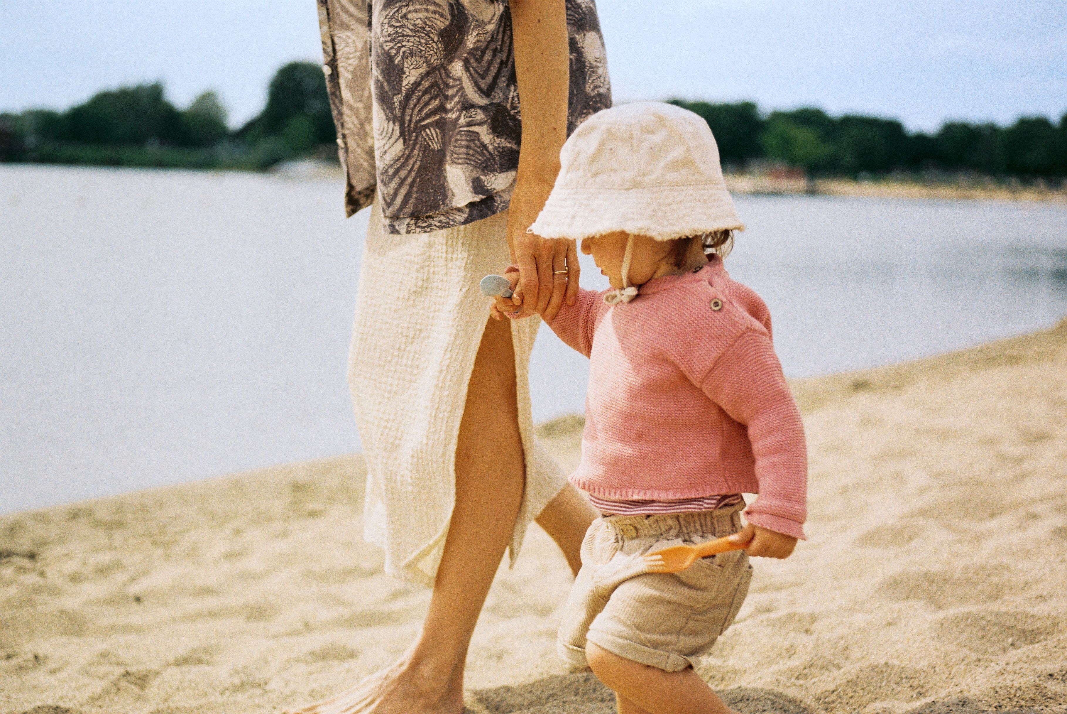 Mutter und Kind halten Hand am Strand der Xantener Südsee.