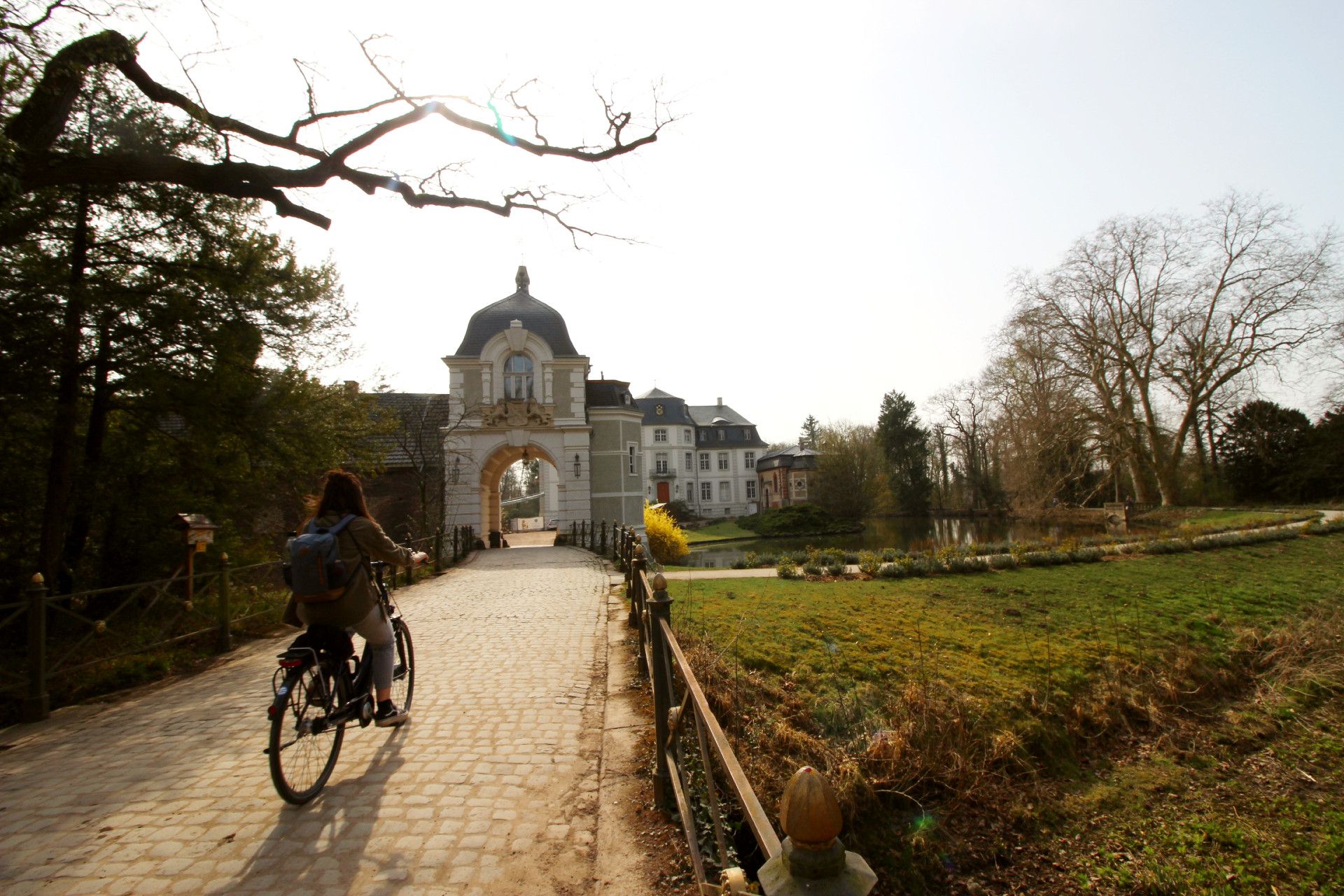 Eine Person auf dem Fahrrad fährt zum Schloss Türnich